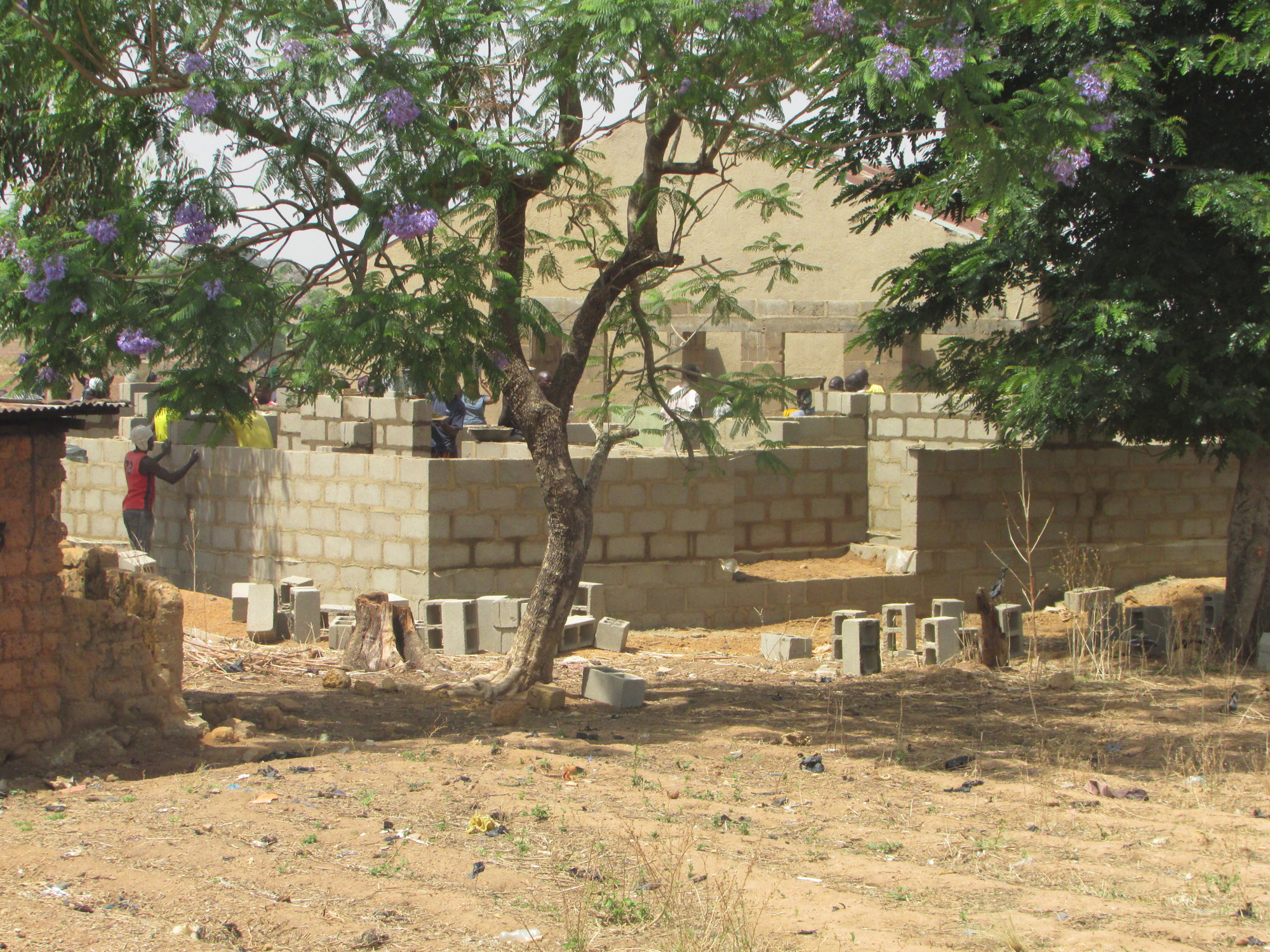 The church sits behind the new home under construction for the village pastor.