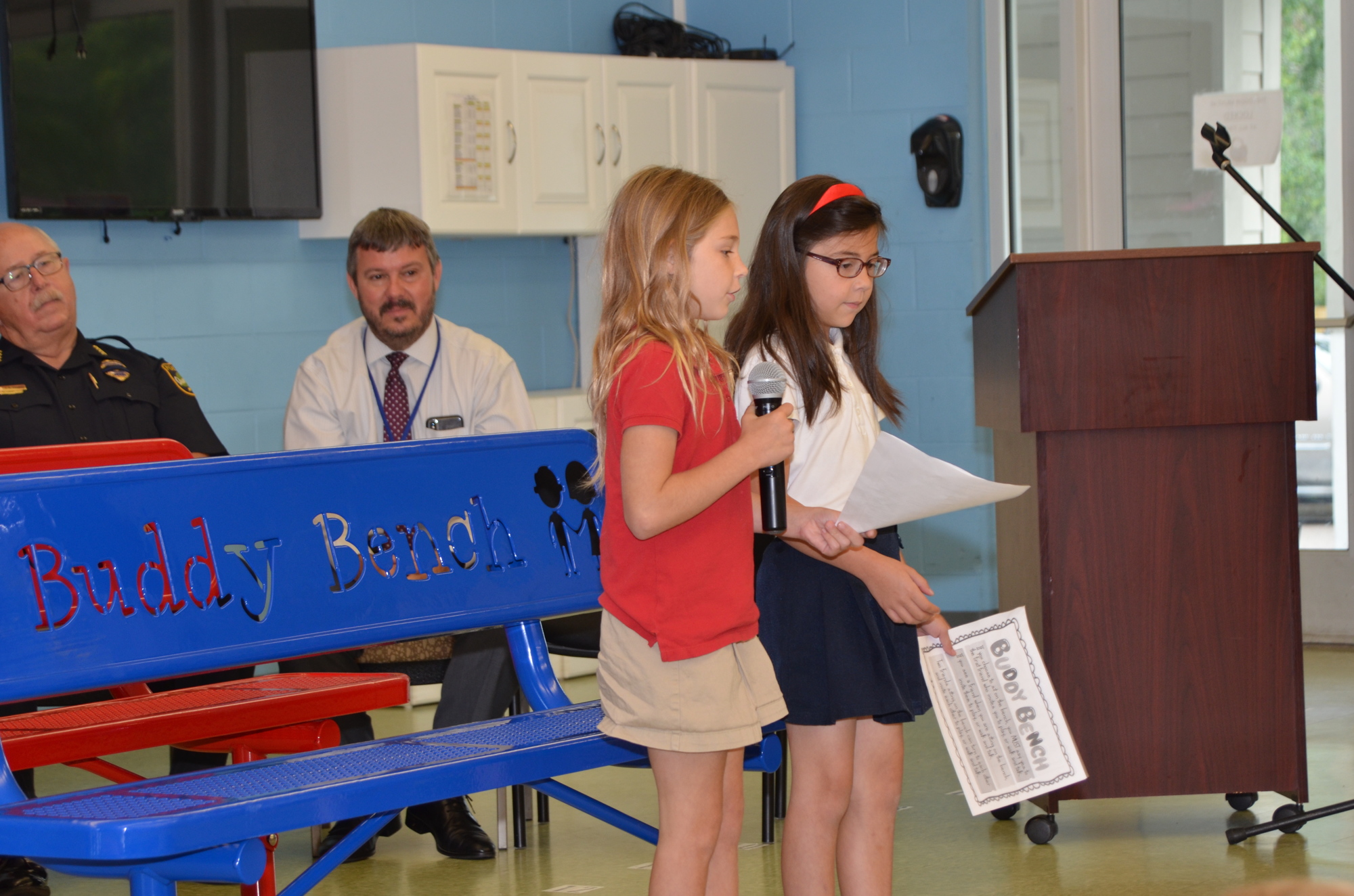Ryelan Walker, left, and Gabriella Rosario read the Buddy Bench rules to the audience.