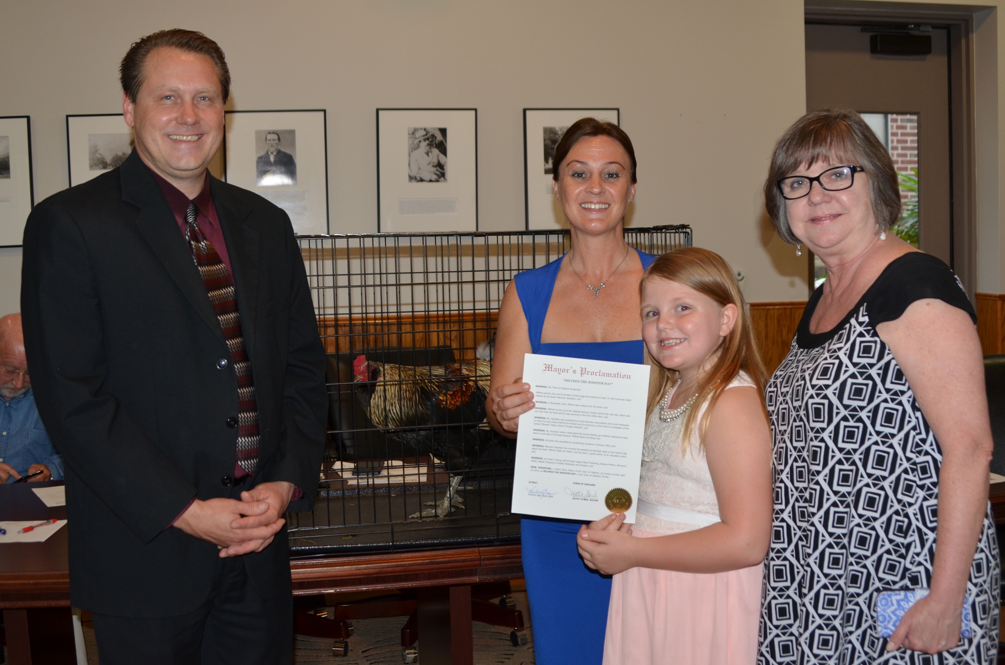 Oakland Mayor Kathy Stark, right, presents a proclamation in April 2015 to Milfred the rooster and the Jacobson family: Jeff, Maureen and Hannah.