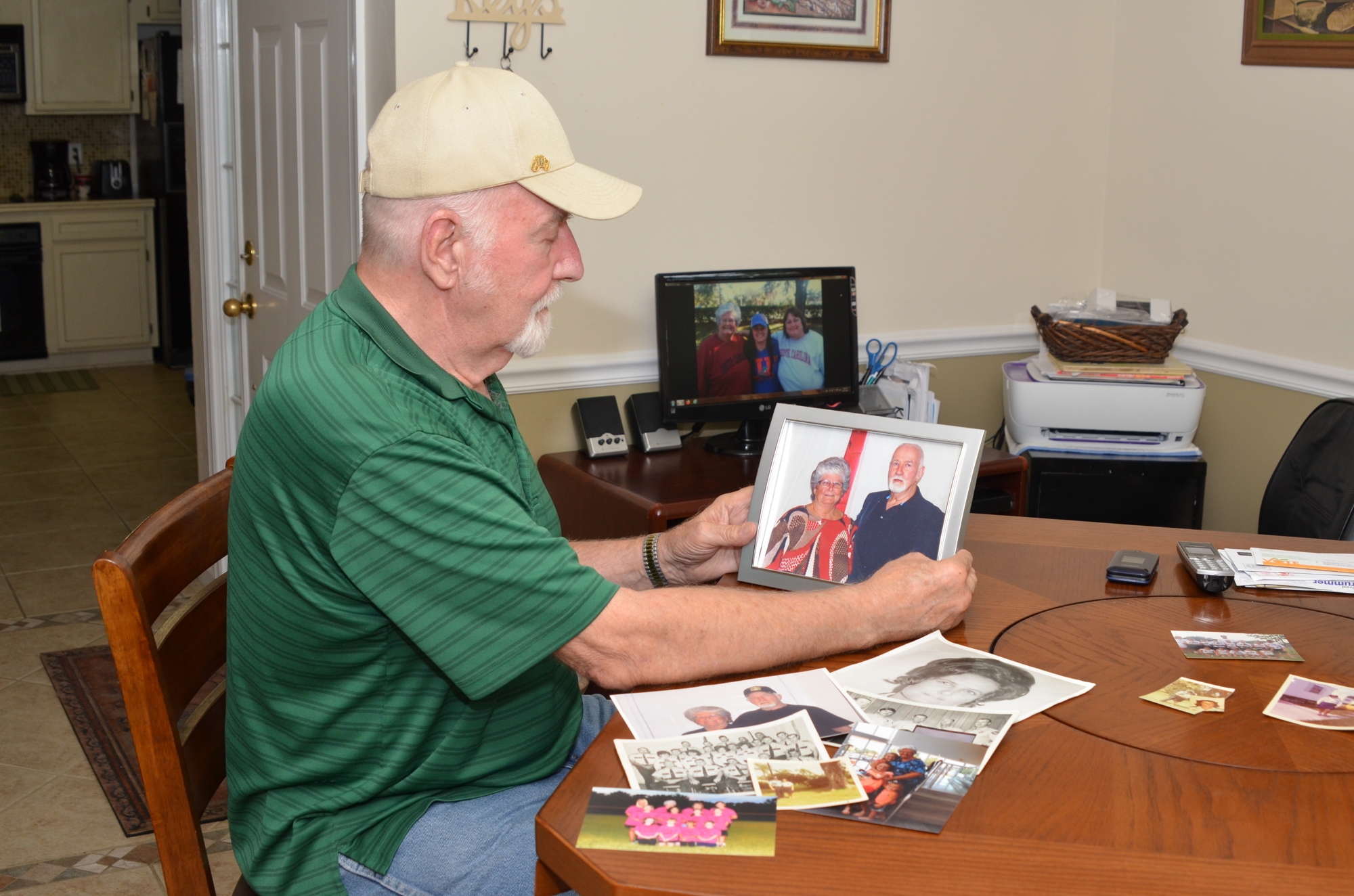 Ed Decker looks over photographs of his wife, Merle, who died Aug. 1.