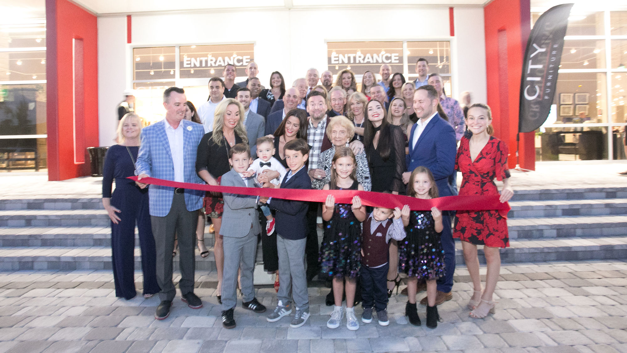 Company and store executives and employees prepare to cut the ribbon signifying the store’s grand opening on Friday, Nov. 9.