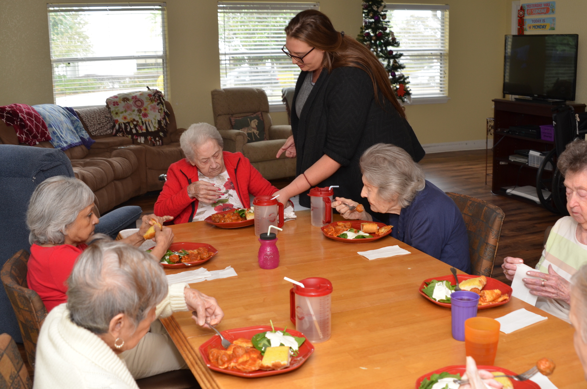 Activities director Amber Holman serves lunch to the residents at The Gardens at Lakeview, in Winter Garden.