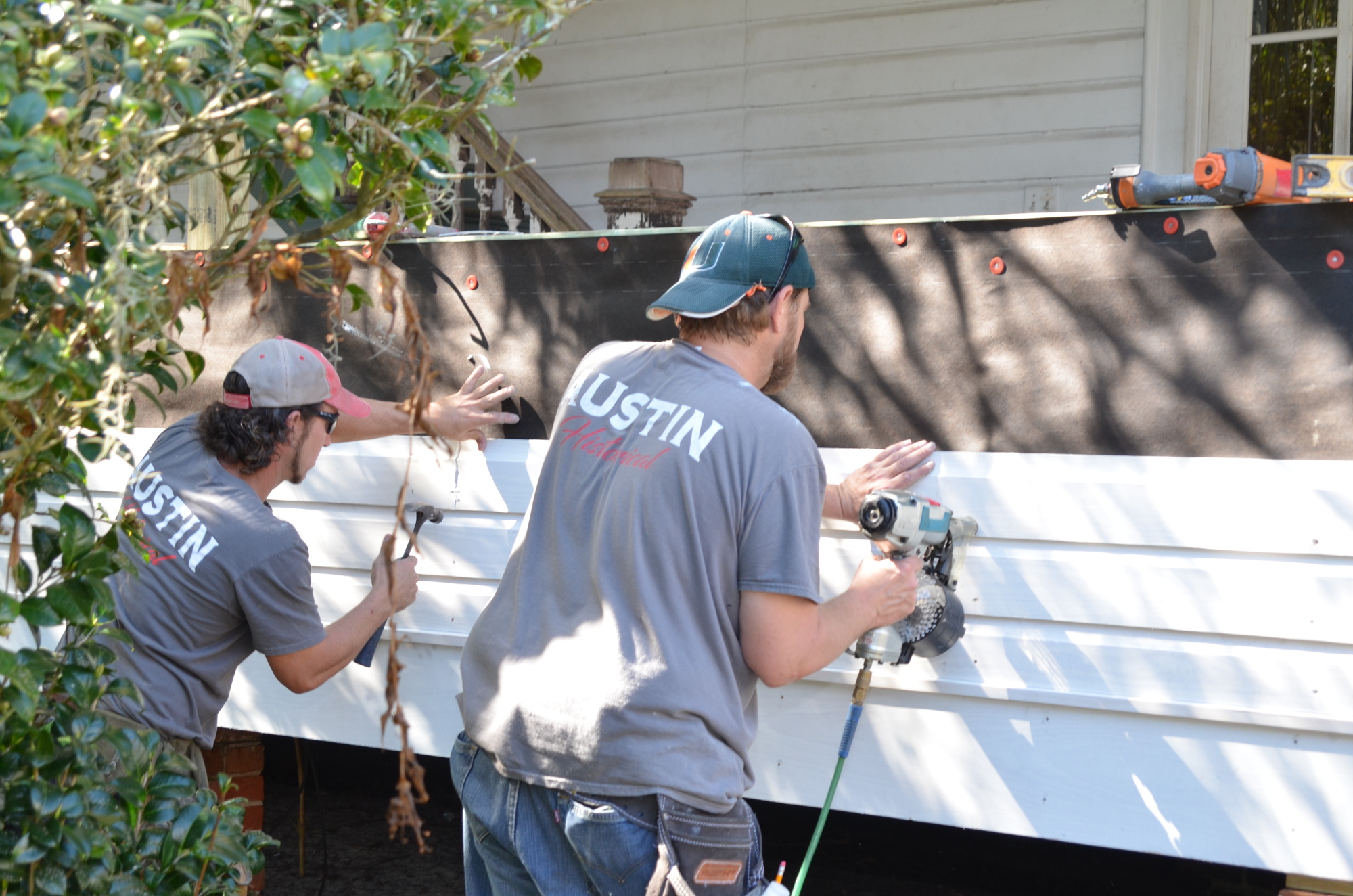 John Morris and Mike Singler replace the siding on Nehrling’s Palm Cottage.