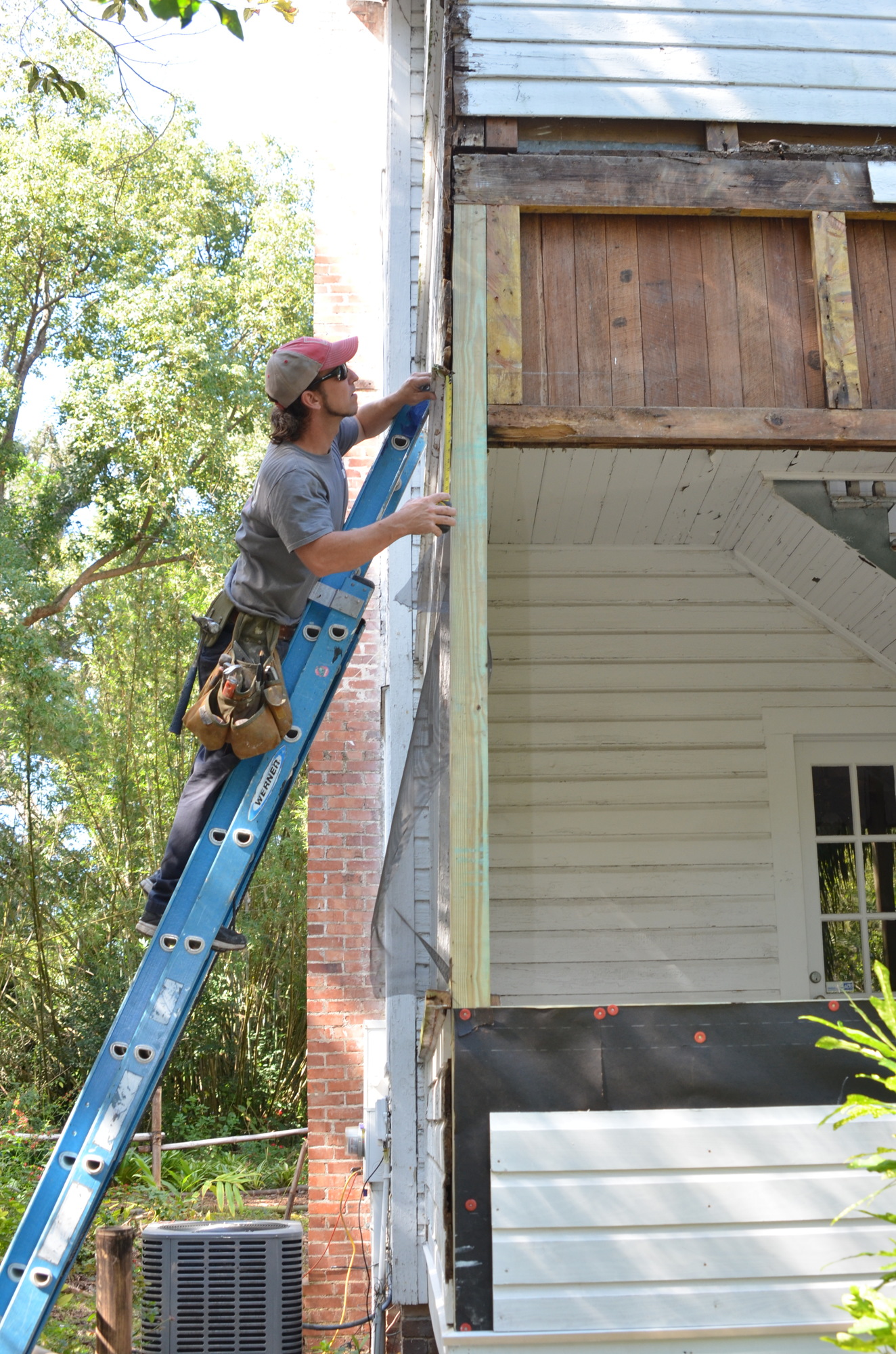 All of the rotted siding is being replaced on Nehrling’s Palm Cottage. John Morris works on the upper level.
