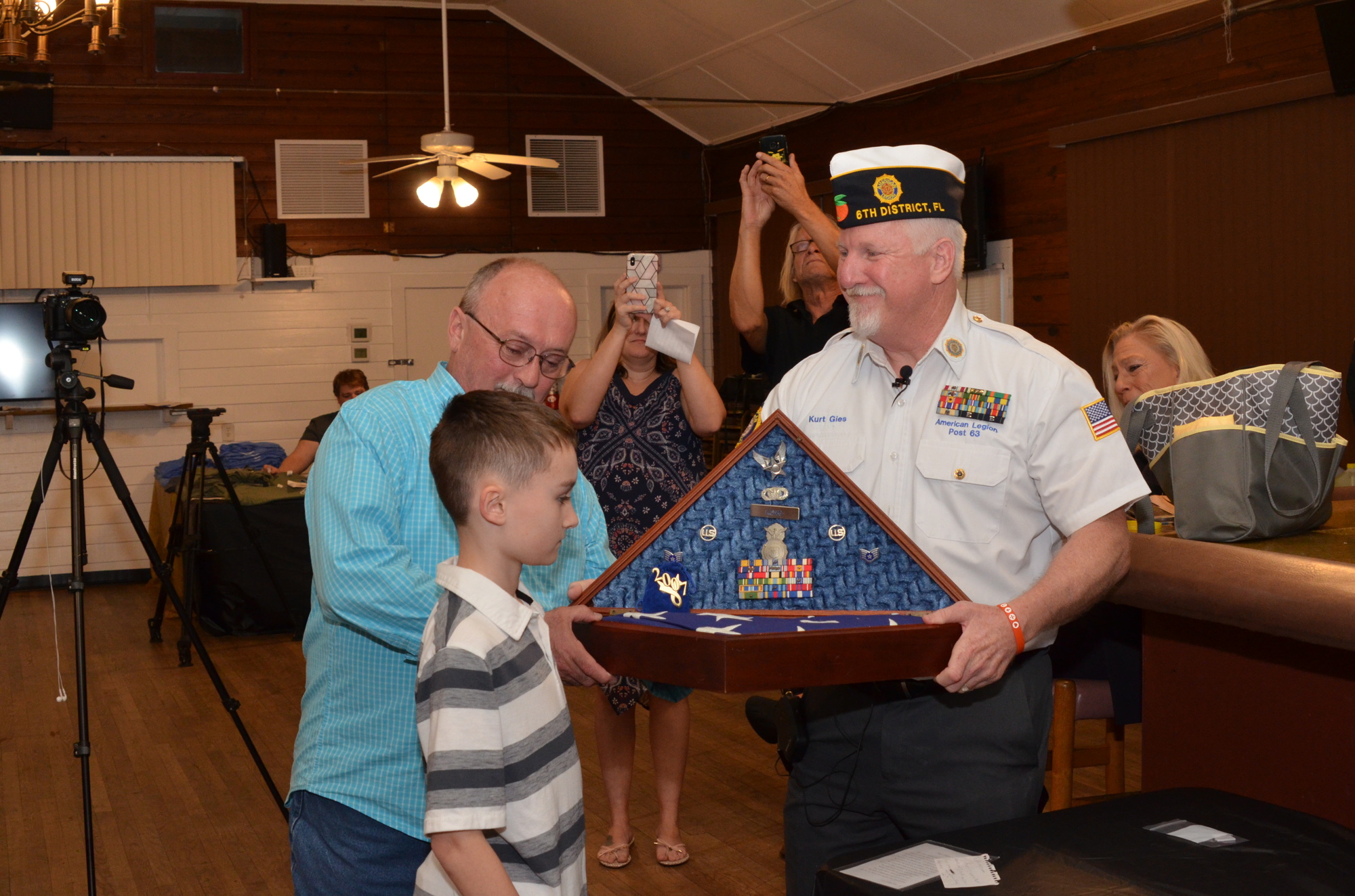 Post Commander Kurt Gies presents the shadow box to Charlie Long and his grandson, Trip Long.