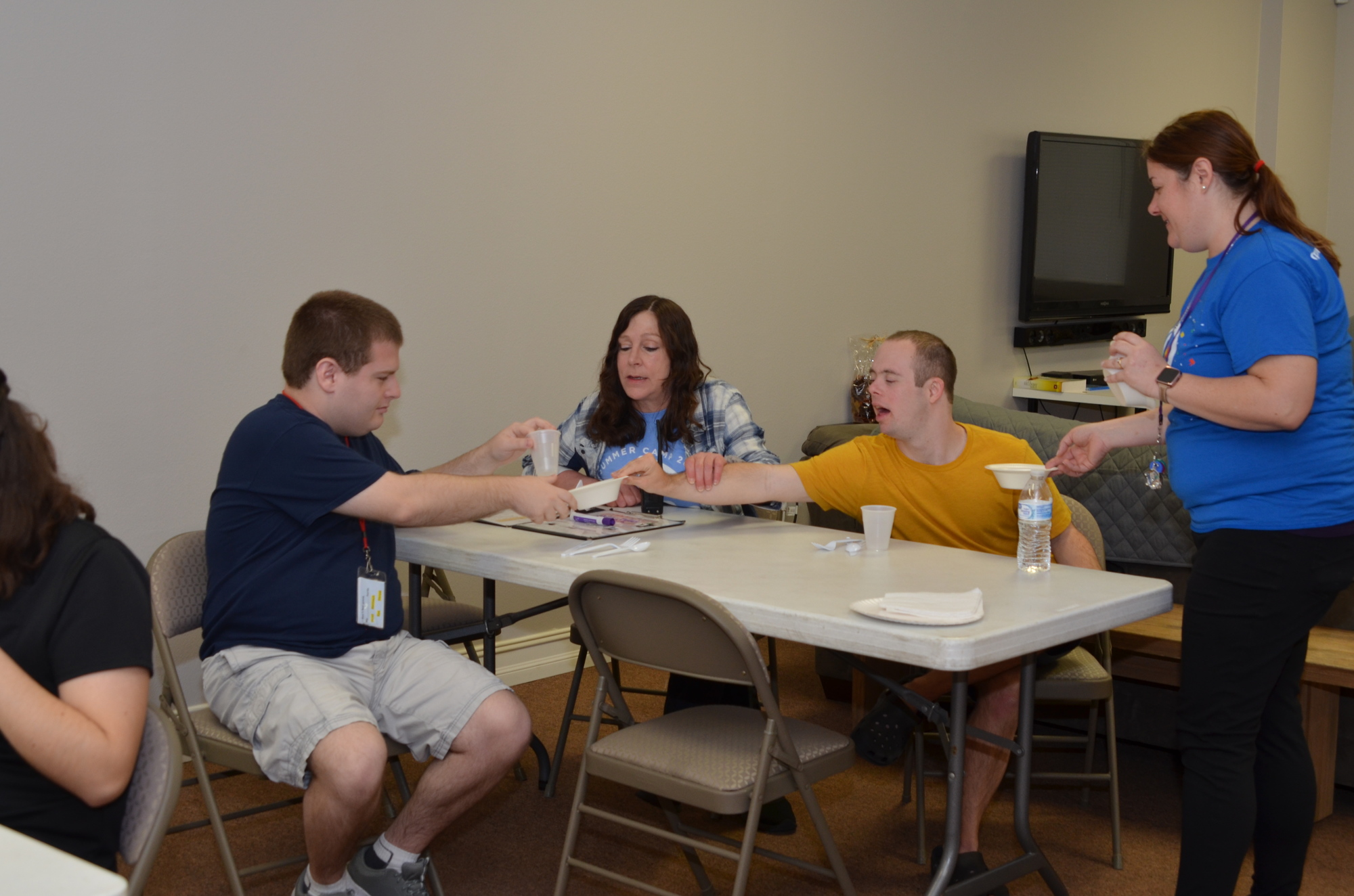 Kelly Calenback, right, and Lisa Earl assist with students Zach Carter, left and Evan Cookson with table-setting instructions.