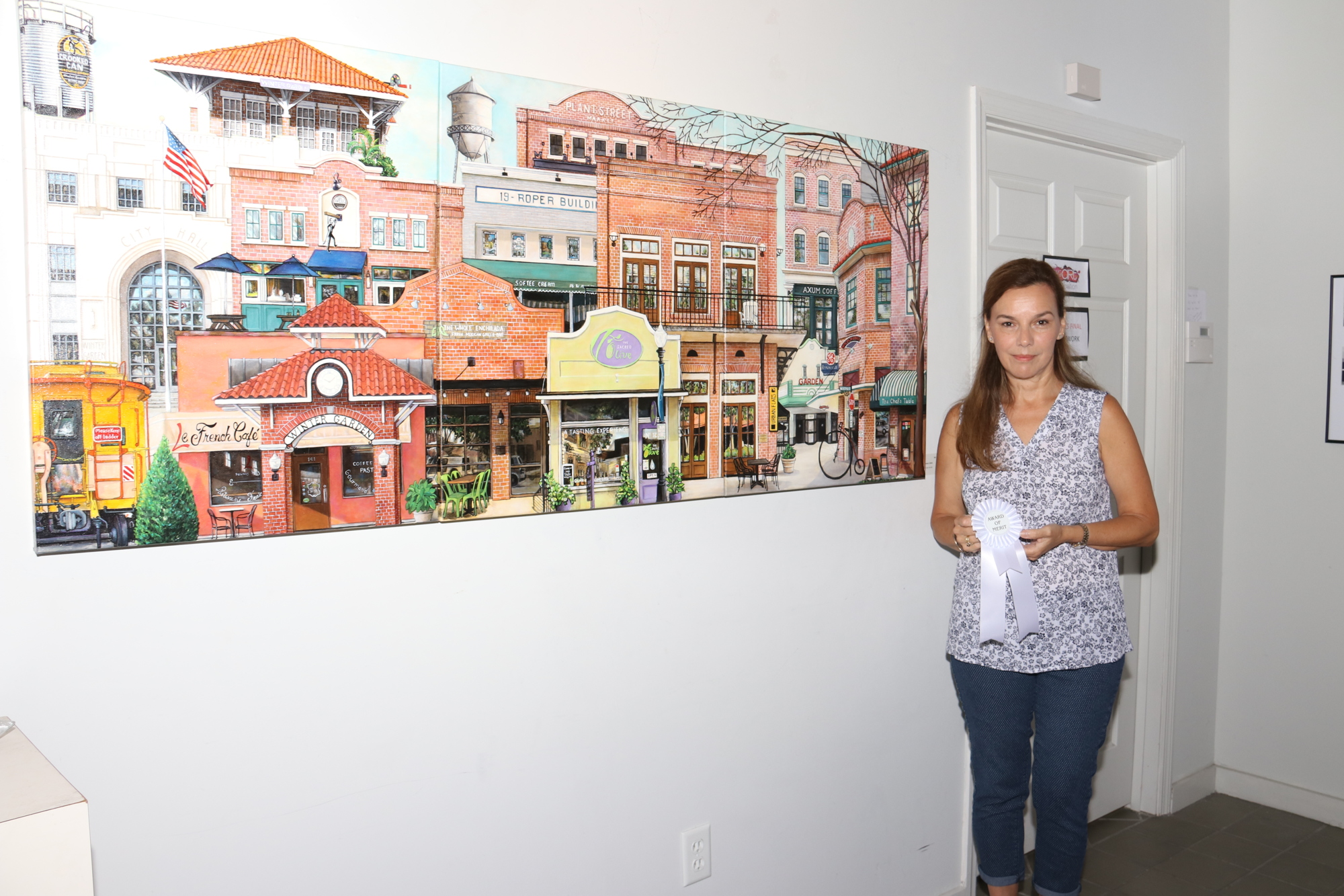  Norma Johns’s painting featured in the SoBo Gallery’s Top Choice Art Exhibition is a collage of the buildings along Plant Street that make up downtown Winter Garden.