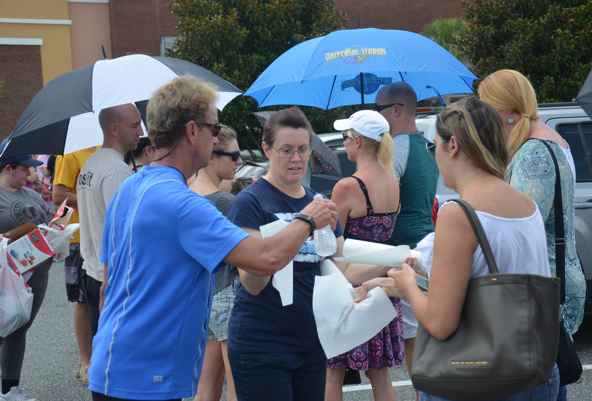 John Busi, left, and an unnamed volunteer passed out water and wet paper towels to residents waiting to donate blood at Winter Garden Village on Sunday afternoon.