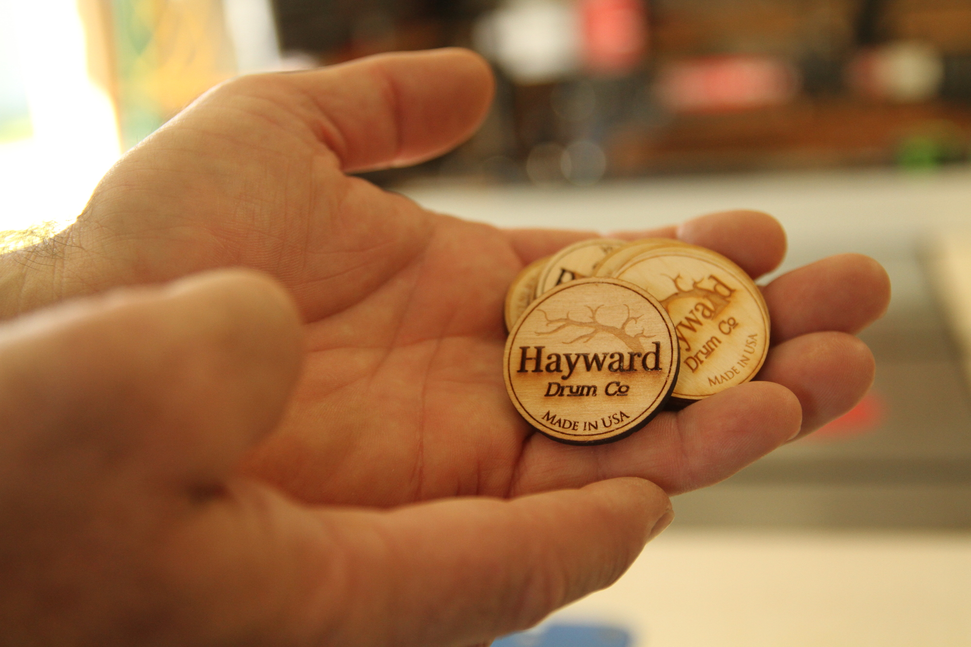 Mark Palermo, a friend of Marc Hayward, uses a laser-etching machine to manufacture badges for Hayward’s drums.