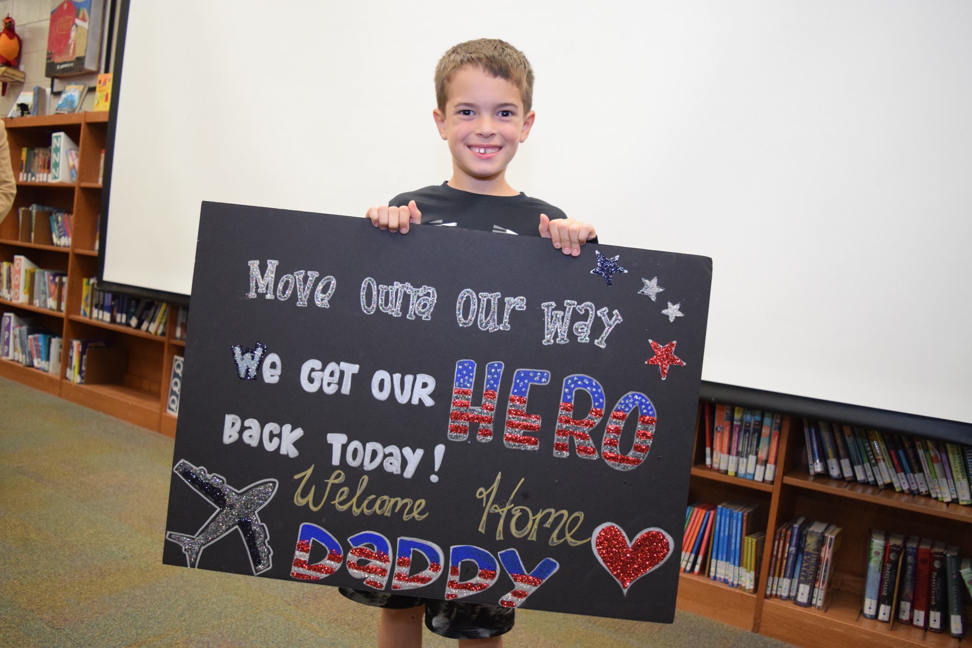 Chase Phillips, 7, proudly held up a sign welcoming his dad back home.