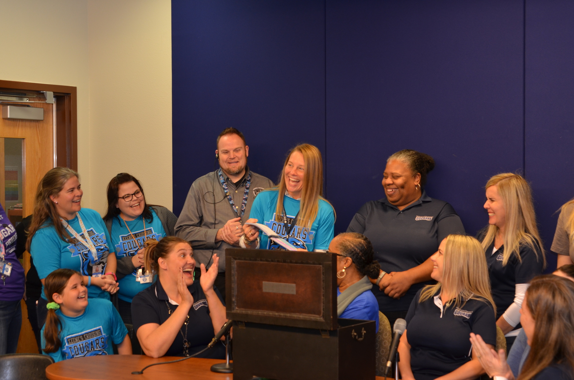 Teachers and staff react to one of the items pulled from the time capsule.