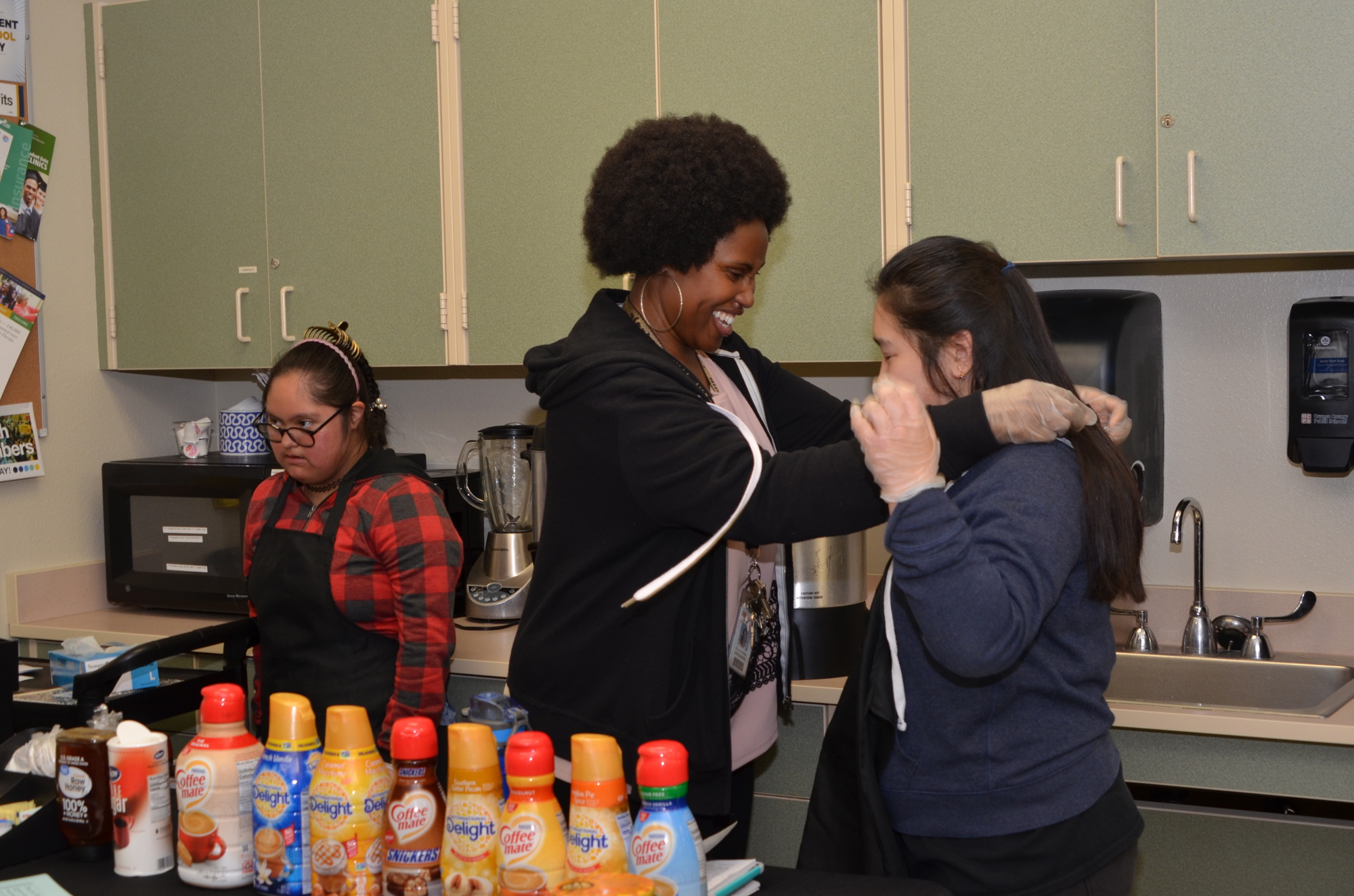 Special-needs teacher Olajumoke Adebimpe runs the Jump Start Café! with her students at Ocoee High School. Natalia Barriga-Sanchez, left, is one of the 10 who operate the coffee stand. With her is another student, Elizabeth Nguyen.