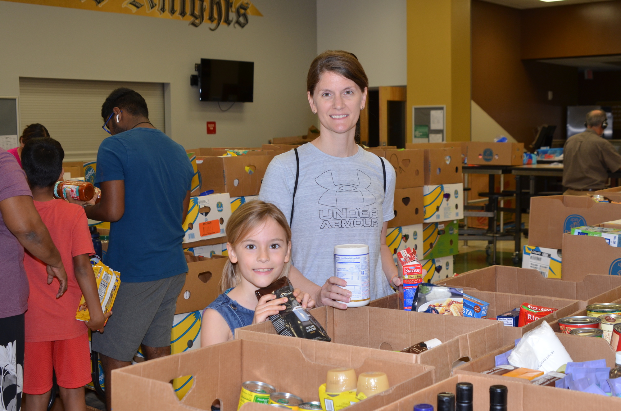 Jessica Cushman, of Ocoee, and her daughter, Maliya, 7, took a shift separating donated items into boxes.
