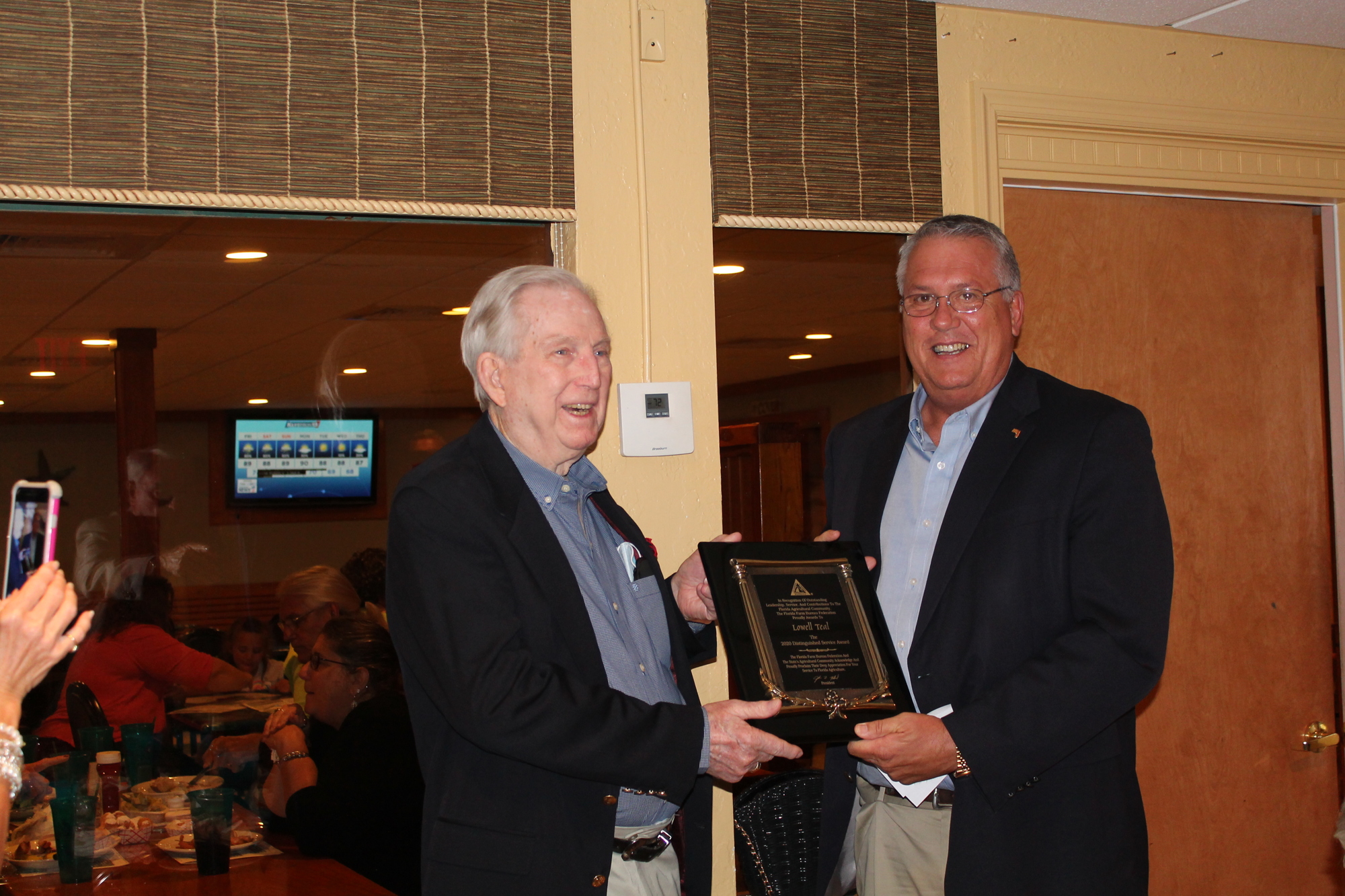 Windermere resident Lowell Teal was recognized with the Florida Farm Bureau’s Distinguished Service Award for 2020, presented by FFB President John Hoblick. Courtesy Orange County Farm Bureau