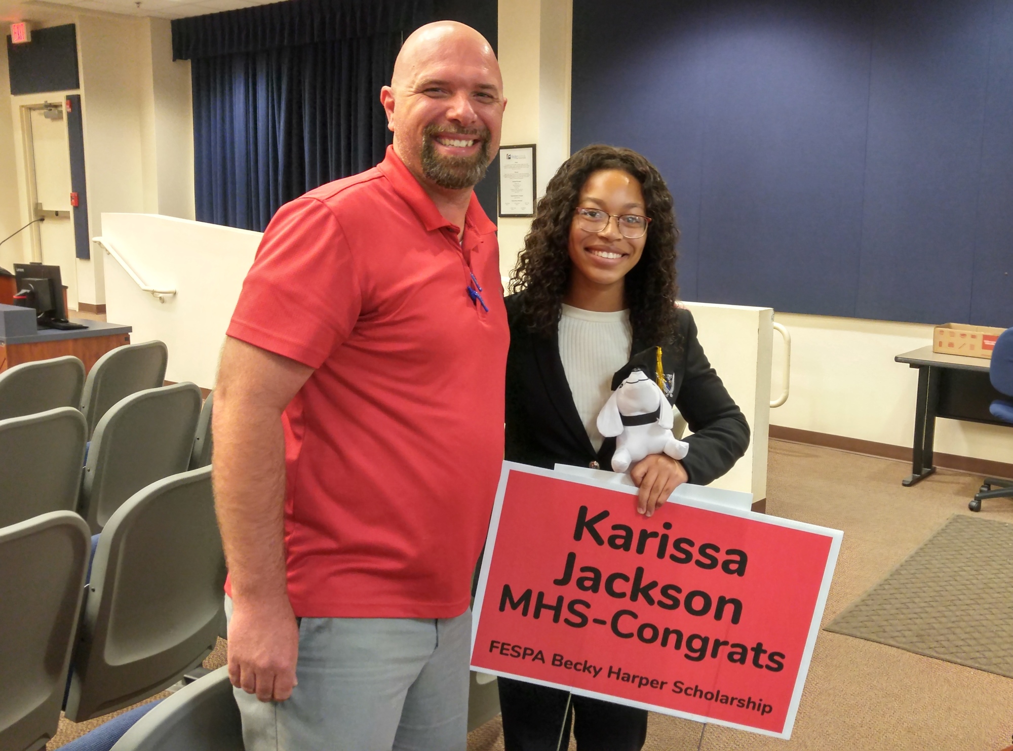 Flagler Educational Support Professional Association president Bron Hudson presents Matanzas graduate Karissa Jackson with a yard sign honoring her as the recipient of the FESPA Becky Harper Scholarship. Photo by Brent Woronoff