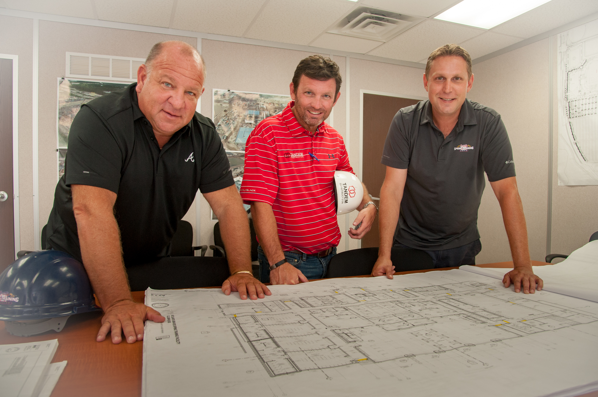 Lori Sax. Braves Vice President of Florida Operations Mike Dunn, Tandem Construction Senior Vice President Brian Leaver and Fawley Bryant Architecture Project Manager Kirk Bauer look at plans for the Braves facility.
