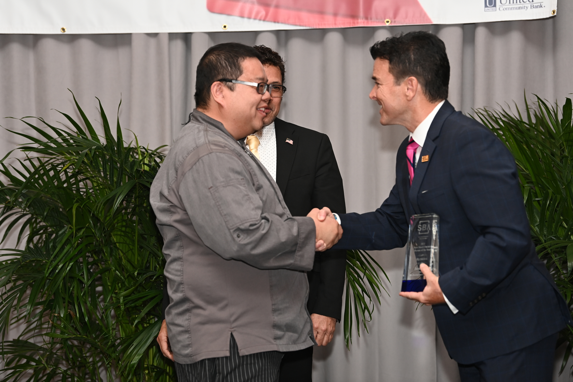 Dennis Chan accepts his award from U.S. Small Business Administration Region IV Administrator Allen Thomas. (Florida SBDC)