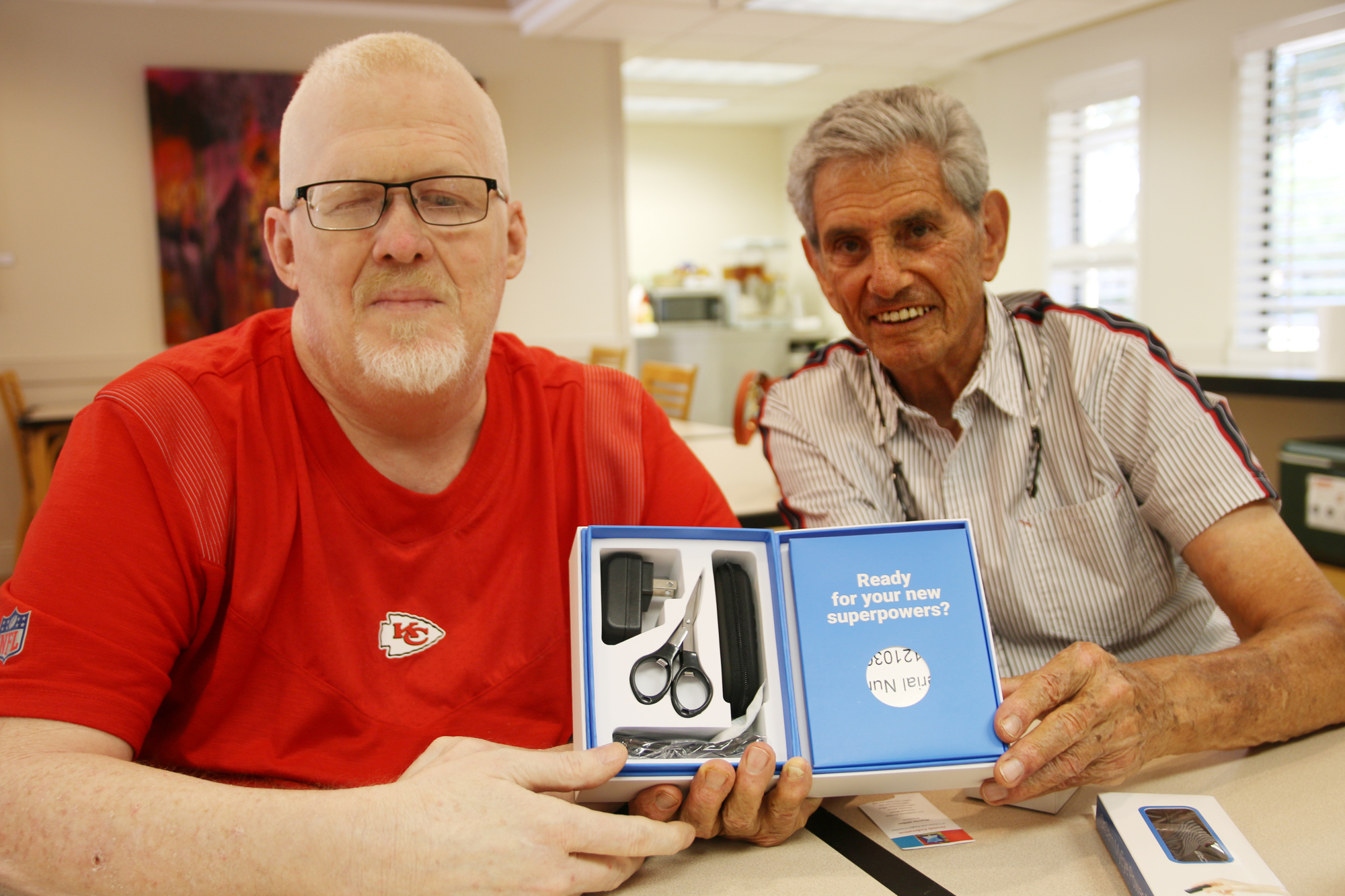 Paul DePalma and Marvin Miller, president of the Jewish Federation, show off the OrCam MyEye device. Photo by Jarleene Almenas
