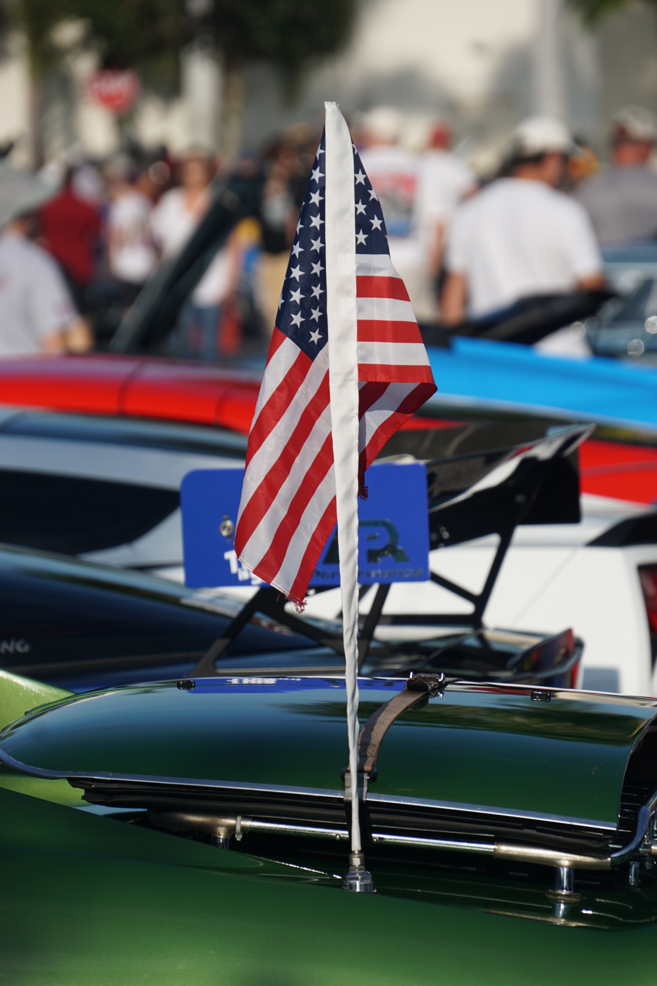 An American flag flies from the antenna of a sports car in a recent Cars and Coffee event.