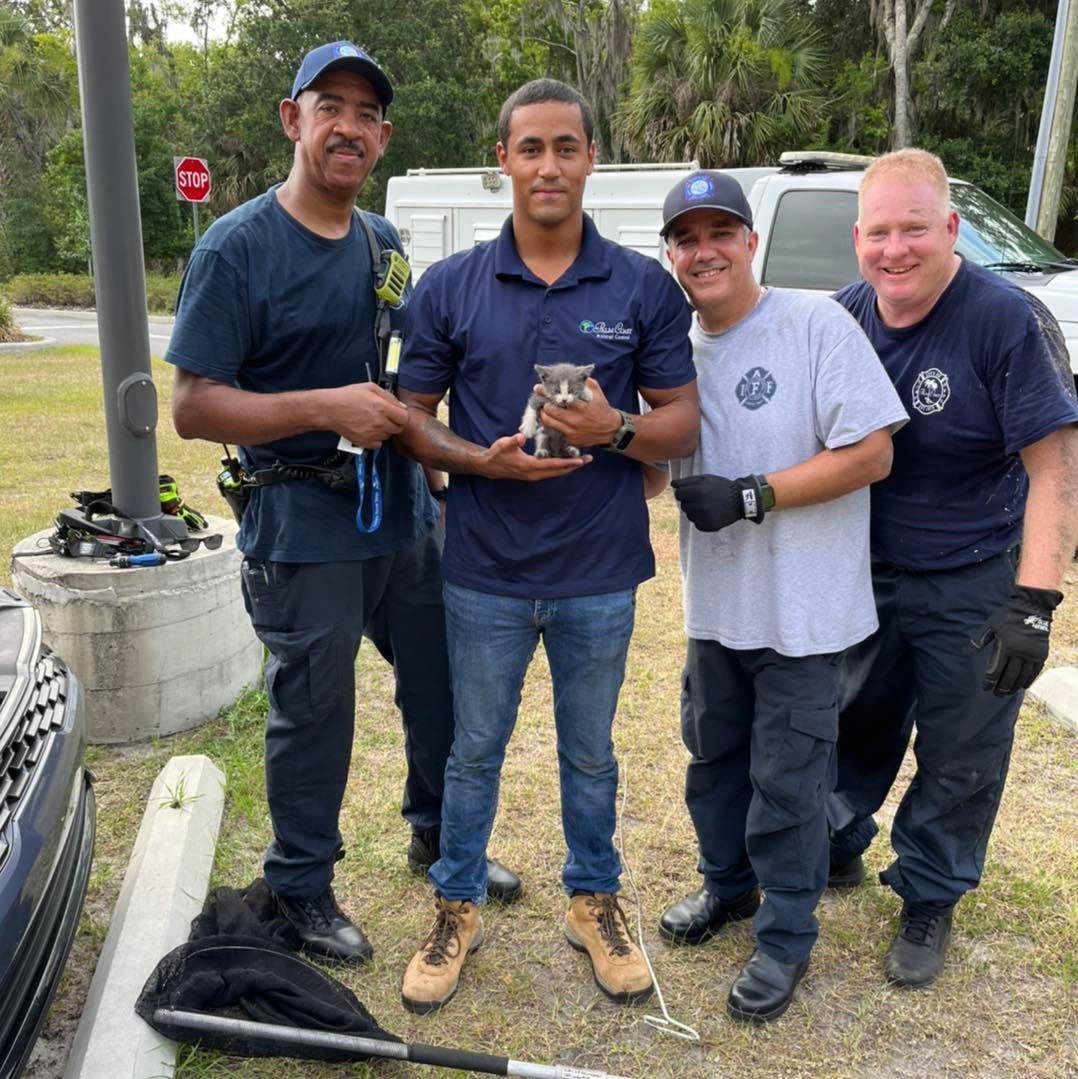 Animal Control Officer Kasey Hagan holds Turbo, with city firefighters. Photo courtesy of the city of Palm Coast