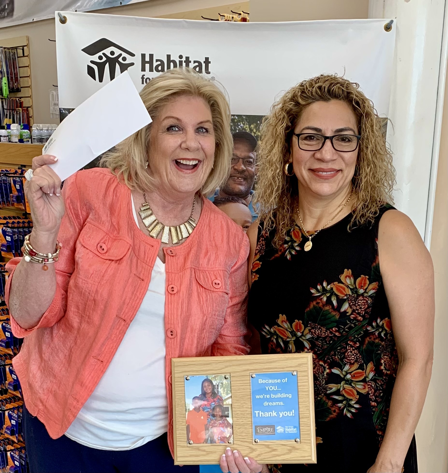 Marilyn Hattaway, executive director of West Orange Habitat for Humanity, accepted a check from Empire Finish Systems LLC.