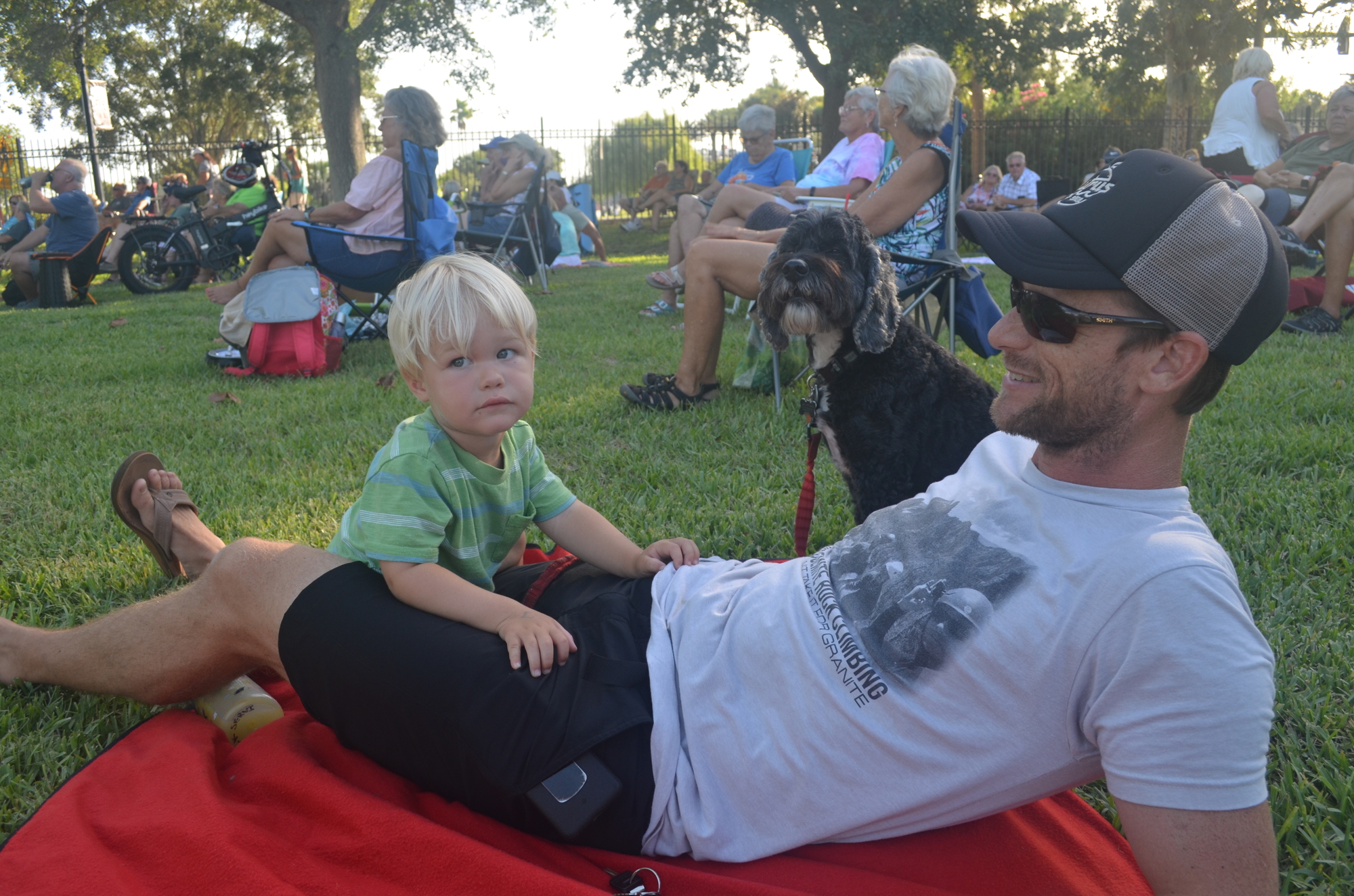Jack and Josh Servi, and their dog Calvin, set up their blanket in Rockefeller Gardens to enjoy the first Summer Sounds concert of the series. Photo by Mia Striegel