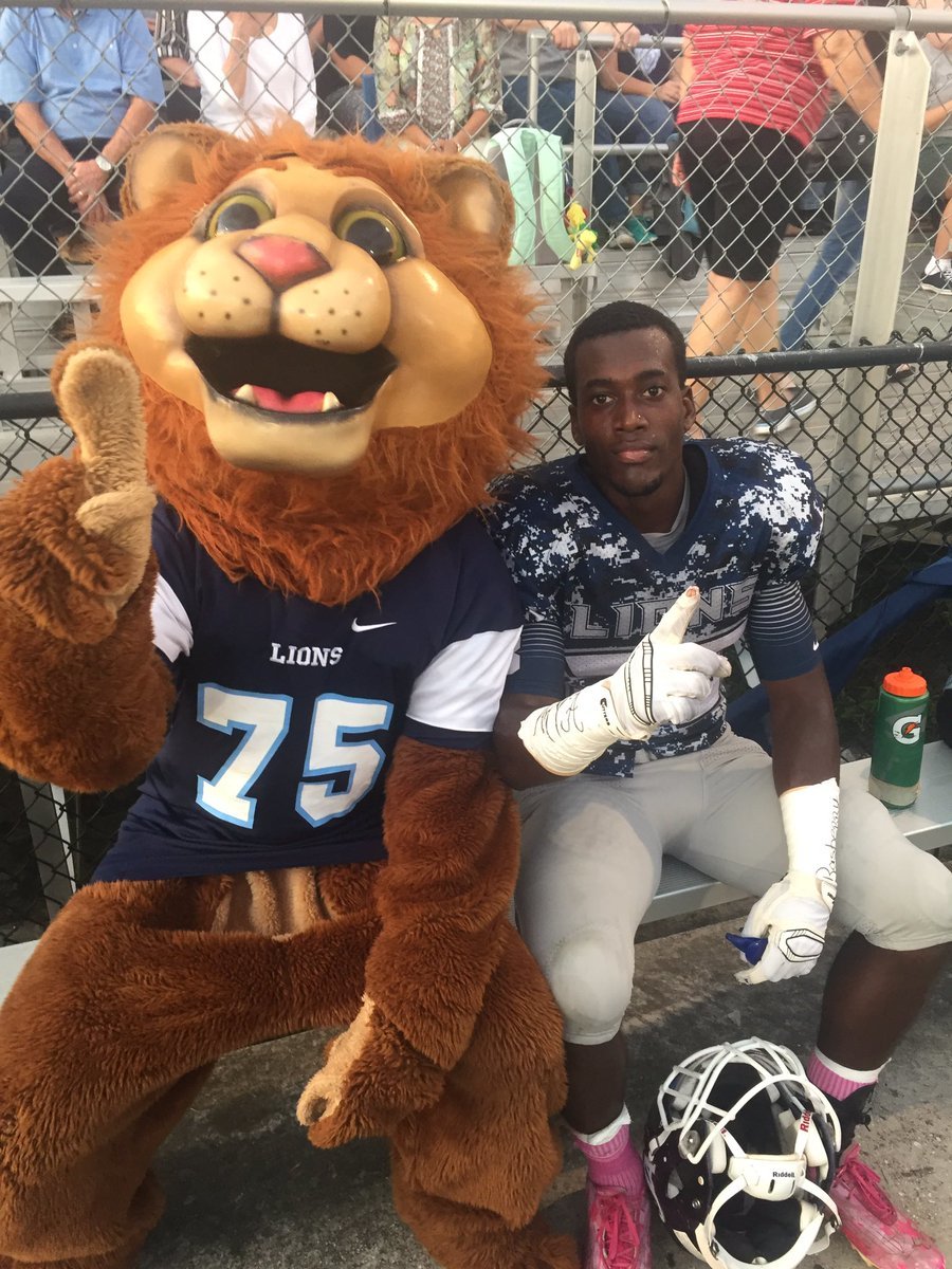 After scoring a touchdown against Cornerstone Charter Sept. 30, Jaquane Patterson smiles for the camera with the Lions' mascot.