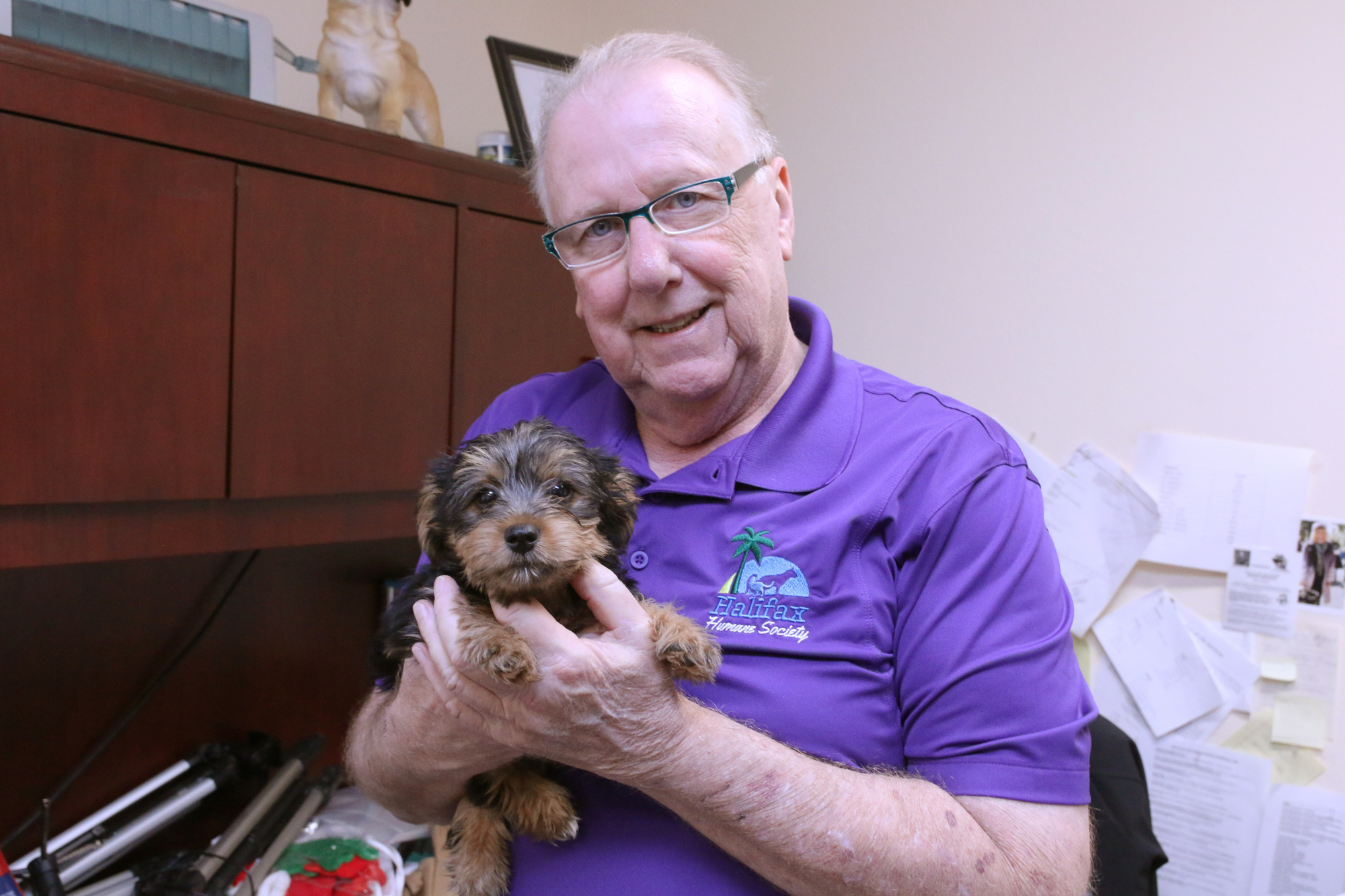 Barry KuKes holds Sonny, a puppy who already has a hold on him. Photo by Jarleene Almenas