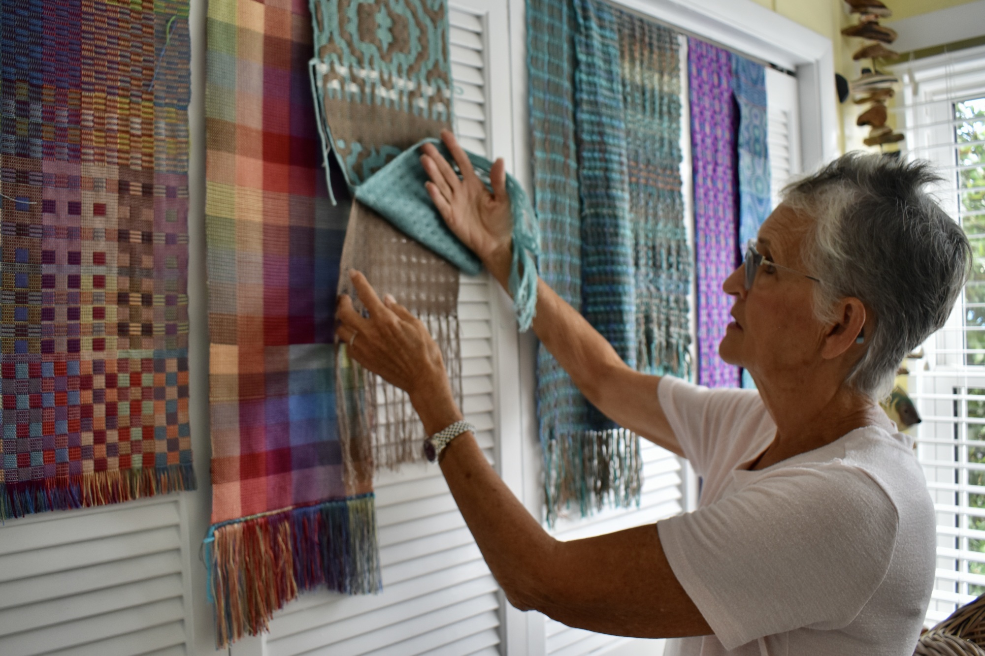 Greer shows off the layers in one of her woven pieces. (Photo by Lesley Dwyer)