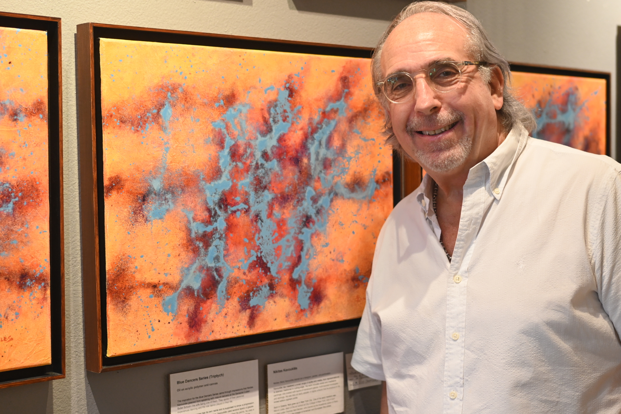 Cary Greenberg stands in front of an oil painting by Nikitas Kavoukles. (Photo by Spencer Fordin)