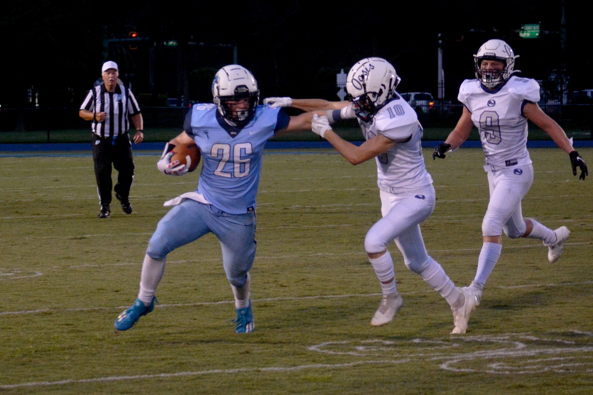 ODA senior Griffin DeRusso (26) stiff arms Oasis junior Christopher Moorehead. DeRusso has four touchdowns run in the Thunder's first two games. (Photo by Ryan Kohn.)