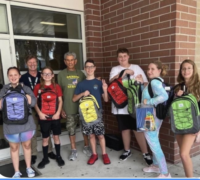 Hinson Middle School teacher Joe Vetter, Jewish Federation president Marvin Miller, and students with backpacks. Courtesy photo
