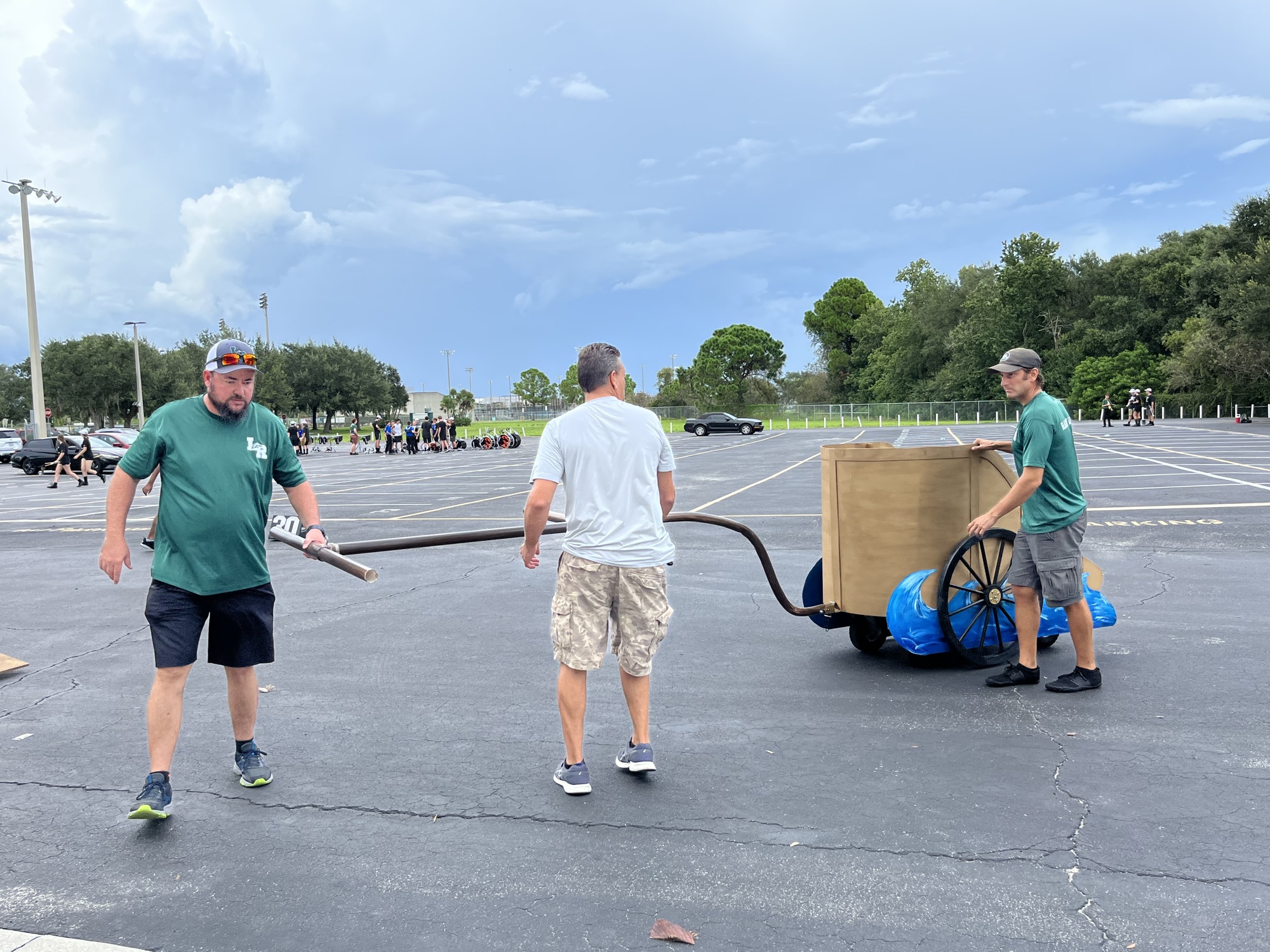 Greg Burden, Marty Gnad and Joseph Flesche, who are Ranch Hands for Lakewood Ranch High School's band, unload the prop chariot from the trailers. The Ranch Hands build the props and load and unload them from trailers.