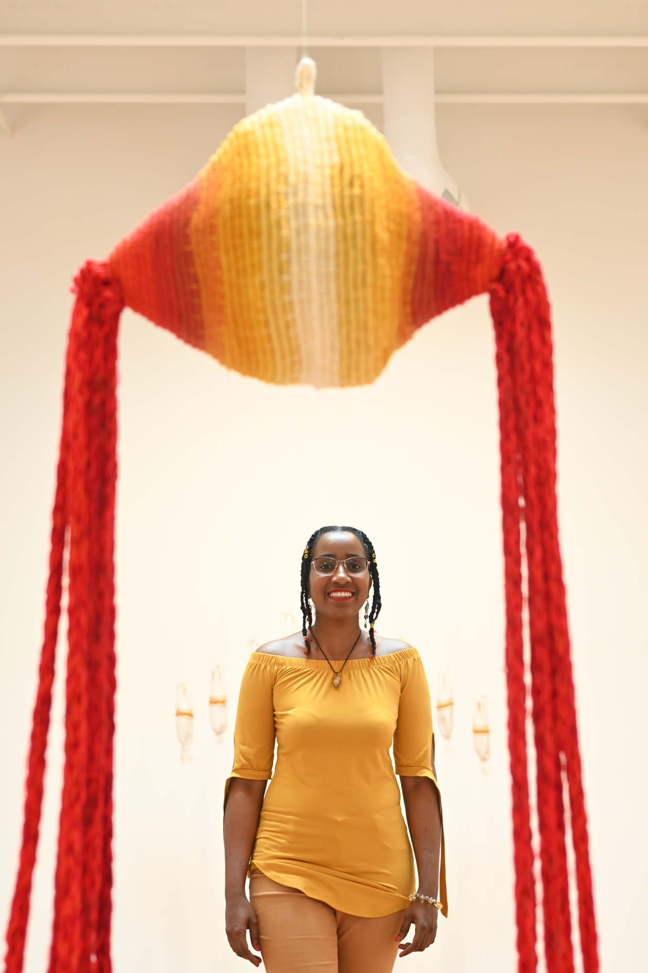 Fiber artist Katrina Coombs stands underneath one of her works at Sarasota Art Museum. (Photo by Spencer Fordin)