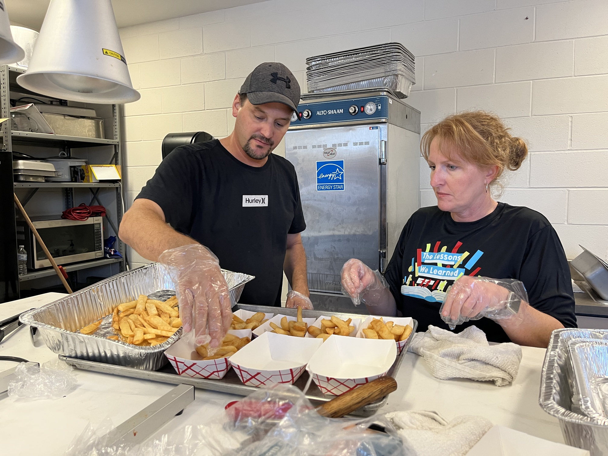 Parents like Braden River High's Jeremy Wade and Vanessa Embry work together in the concessions stand to support the band program. Parents say they become more like family after working hours together.