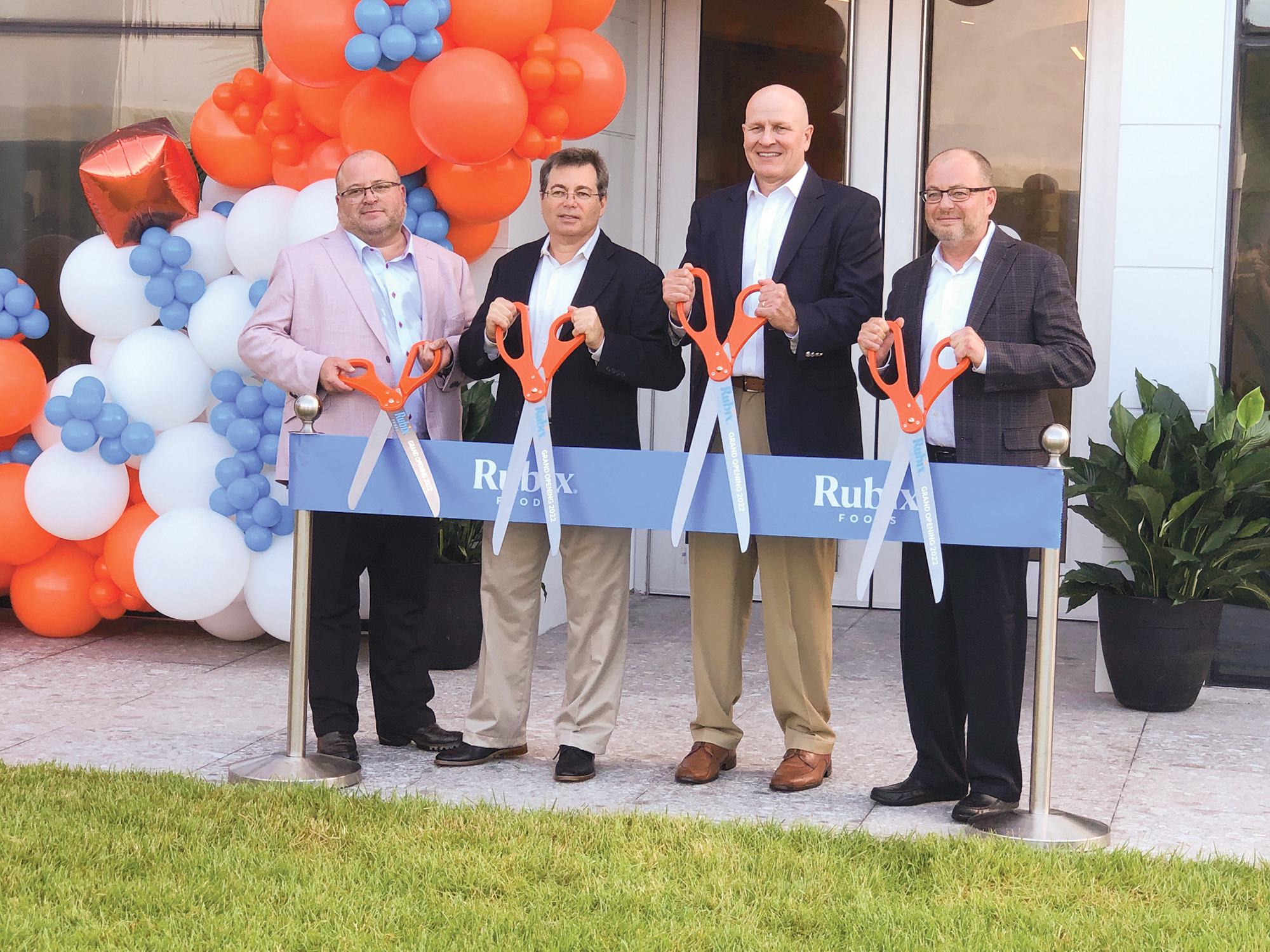 Rubix Foods Executive Vice President Jeffrey Block, CFO and COO Bill Block, President Midd McManus and CEO Andy Block display their branded scissors at a ribbon-cutting at the company’s new headquarters and Innovation Center.