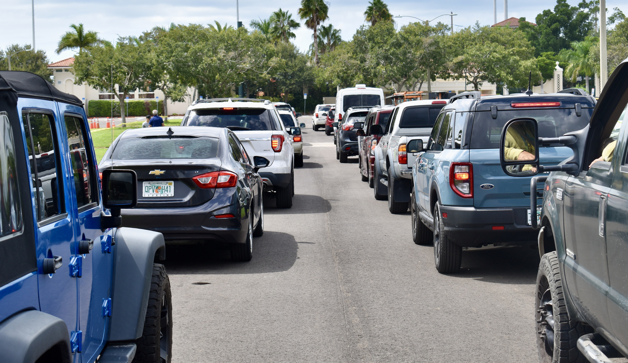 Cars and trucks line up in the parking lot of Ed Smith Stadium on Sunday for sandbag distribution.