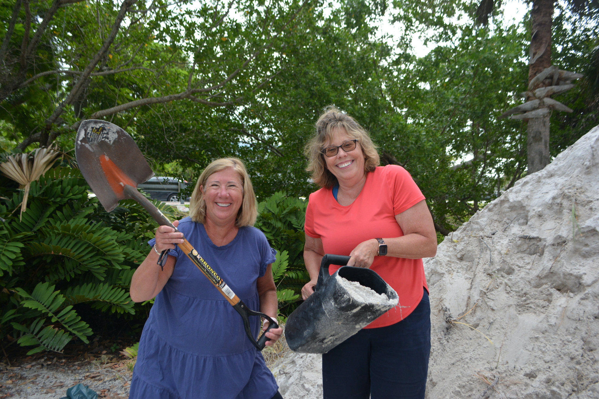 Marti Wood and Starr Shafer work together to fill sandbags ahead of hurricane. (Photo by Lauren Tronstad)