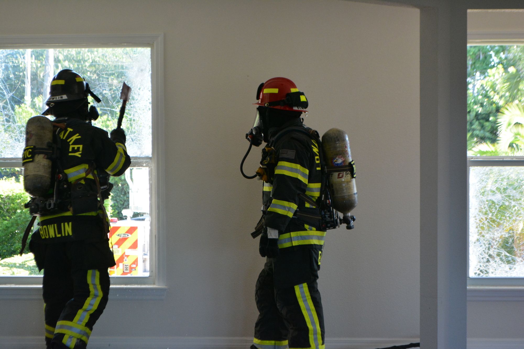 Trey Bowlin hits the hurricane windows as John Elwood observes. (Photo by Lauren Tronstad)