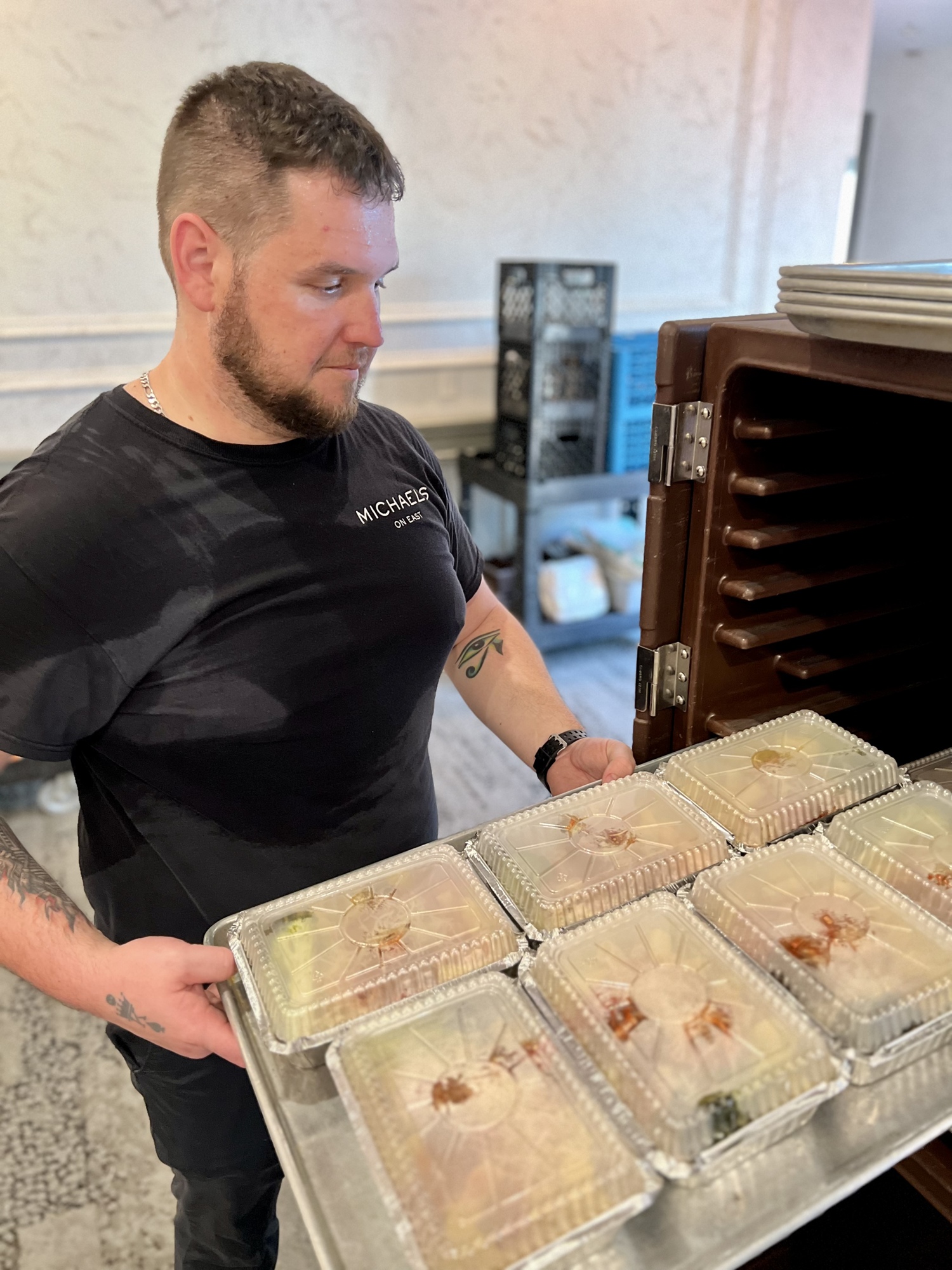 Scott West with Michael's On East packs up a food crate with meals ready for delivery.