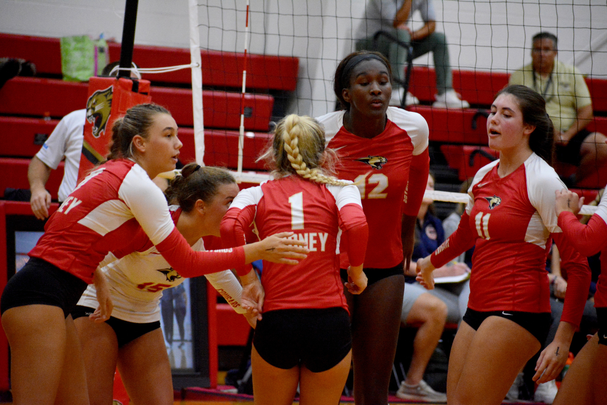 The Cardinal Mooney volleyball team comes together after winning a point against Bradenton Christian on Monday. (Photo by Ryan Kohn.)