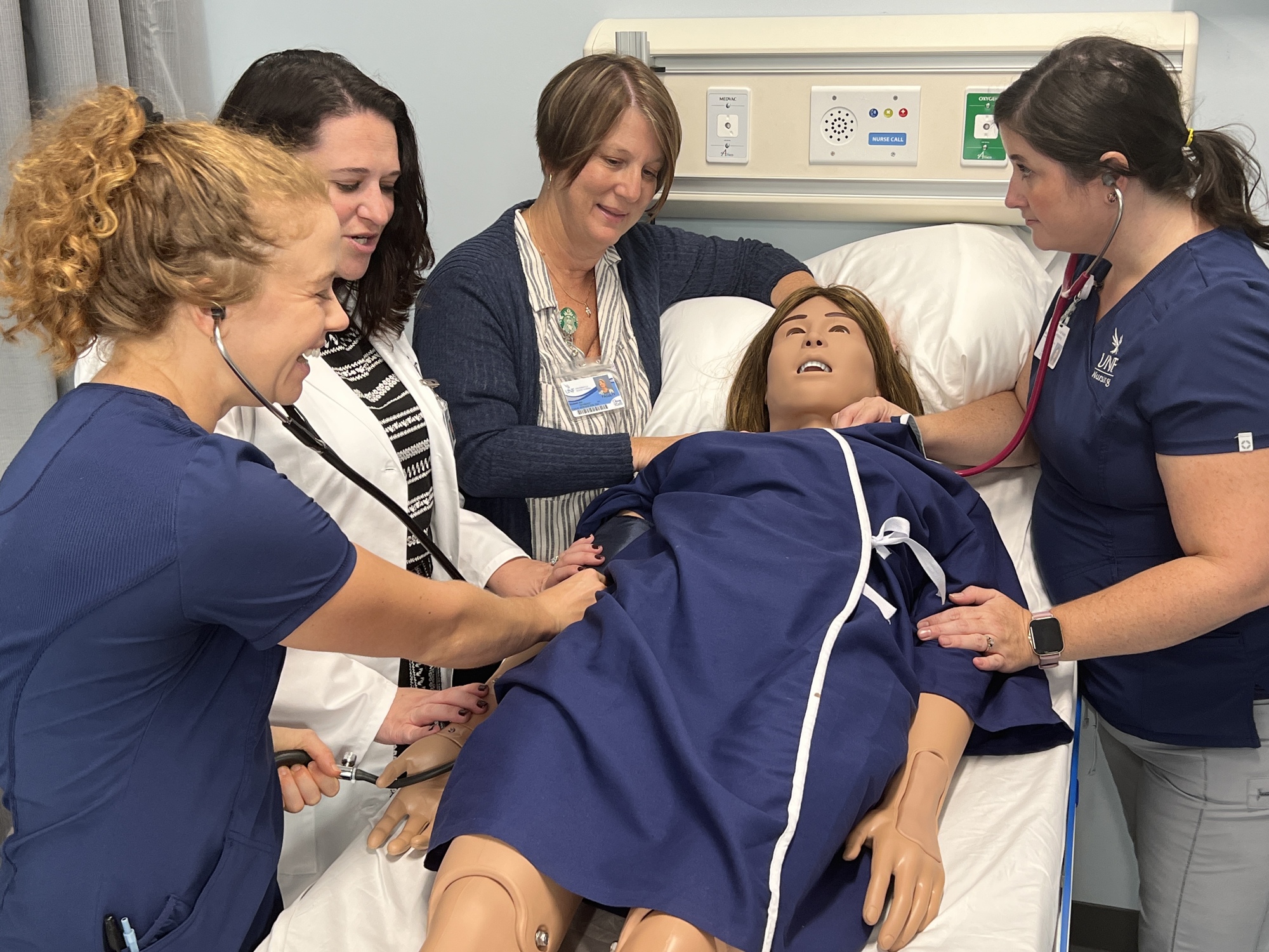 Instructor Marguerite Richards, a registered nurse, demonstrates taking the “pulse” of the robot patient in the HCA Healthcare Center for Clinical Advancement at the University of North Florida.