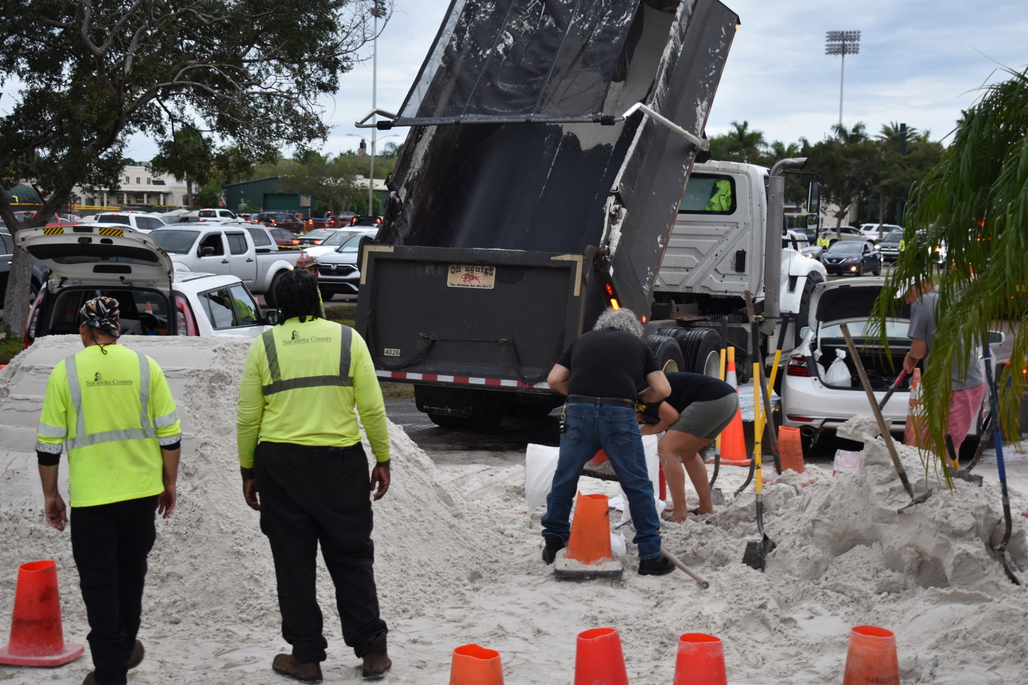 A Sarasota County dump truck creates a new pile of sand at  a county-run sandbag station at Ed Smith Stadium on Tuesday morning. (Photo by Andrew Warfield)
