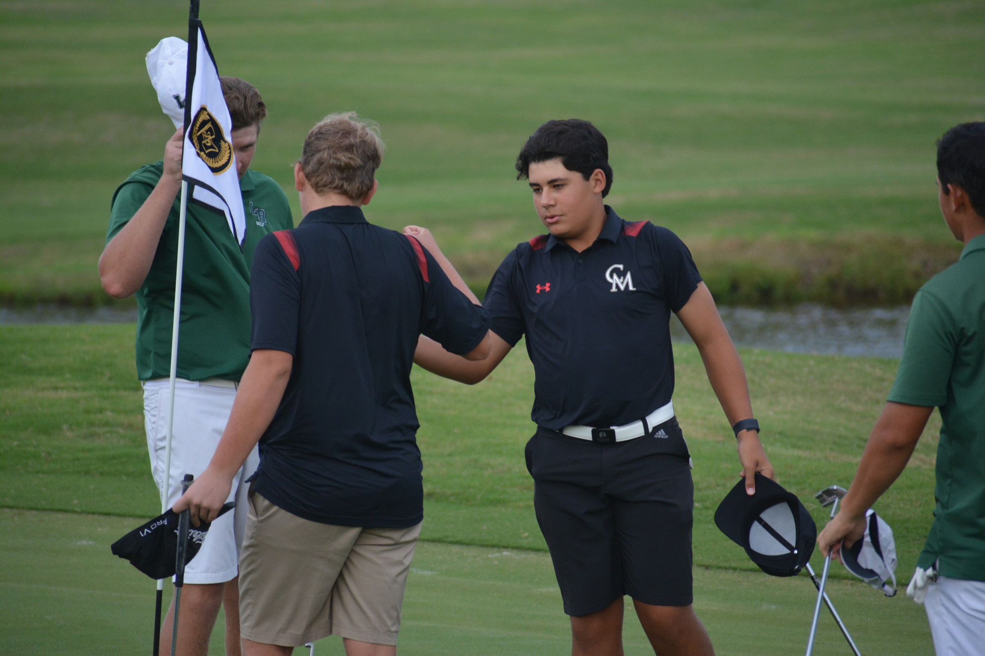 Cardinal Mooney boys golfers Tommy Tyler and Nicolas Bencomo shake hands with each other and with Lakewood Ranch High players after a Tuesday match at Laurel Oak Country Club. (Photo by Ryan Kohn.)