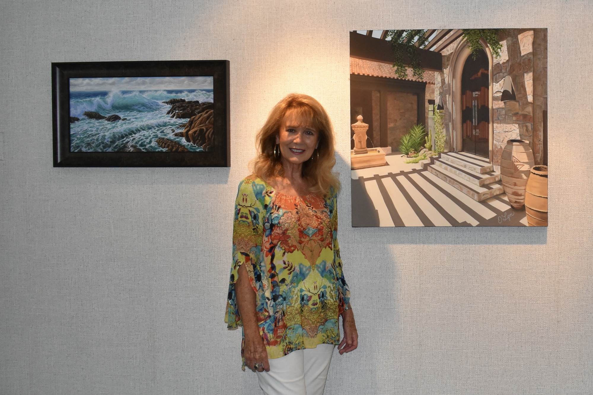 O'Lyn Callahan stands in front of two of her oil paintings for sale this month in the church's art gallery. (Photo by Lesley Dwyer)
