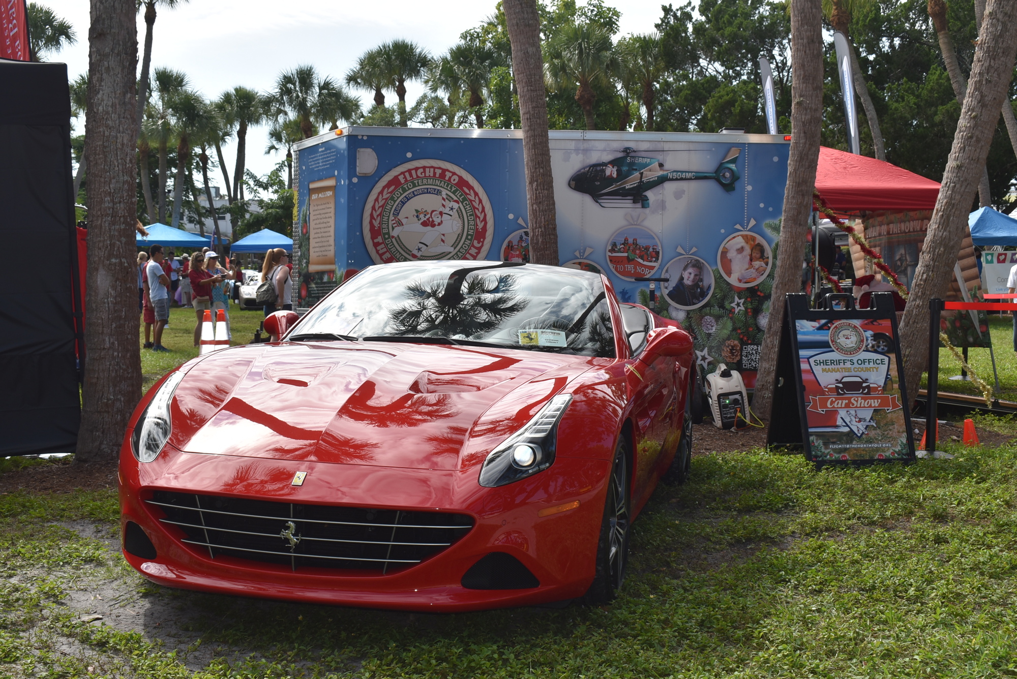 One Ferrari sits next to the trailer for Flight to the North Pole at St. Armands Circle.
