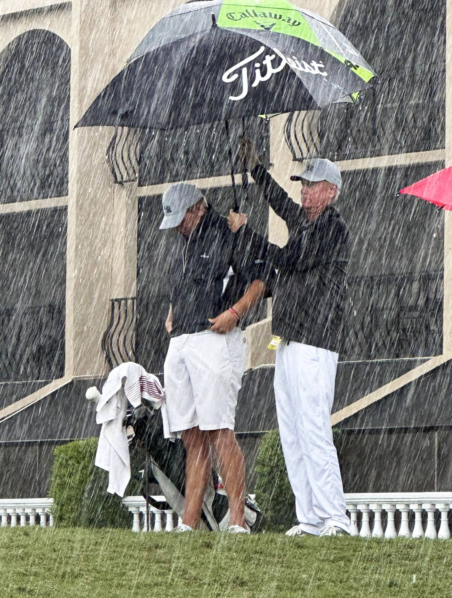 Lakewood Ranch sophomore Henry Burbee thinks about his next shot at the FHSAA state tournament while Coach Dave Frantz holds an umbrella above his head. The tournament was shortened to one round because of rain. (Courtesy photo.)