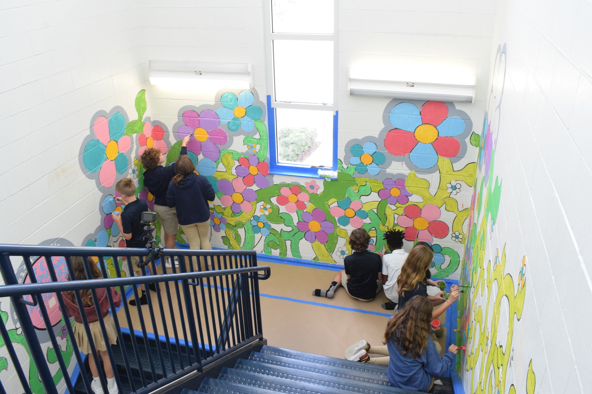 The walls of a stairwell in the Arts Center at Out-of-Door Academy's Uihlein campus becomes the perfect space for a mural that is a part of the Ten Thousand Flowers Project.
